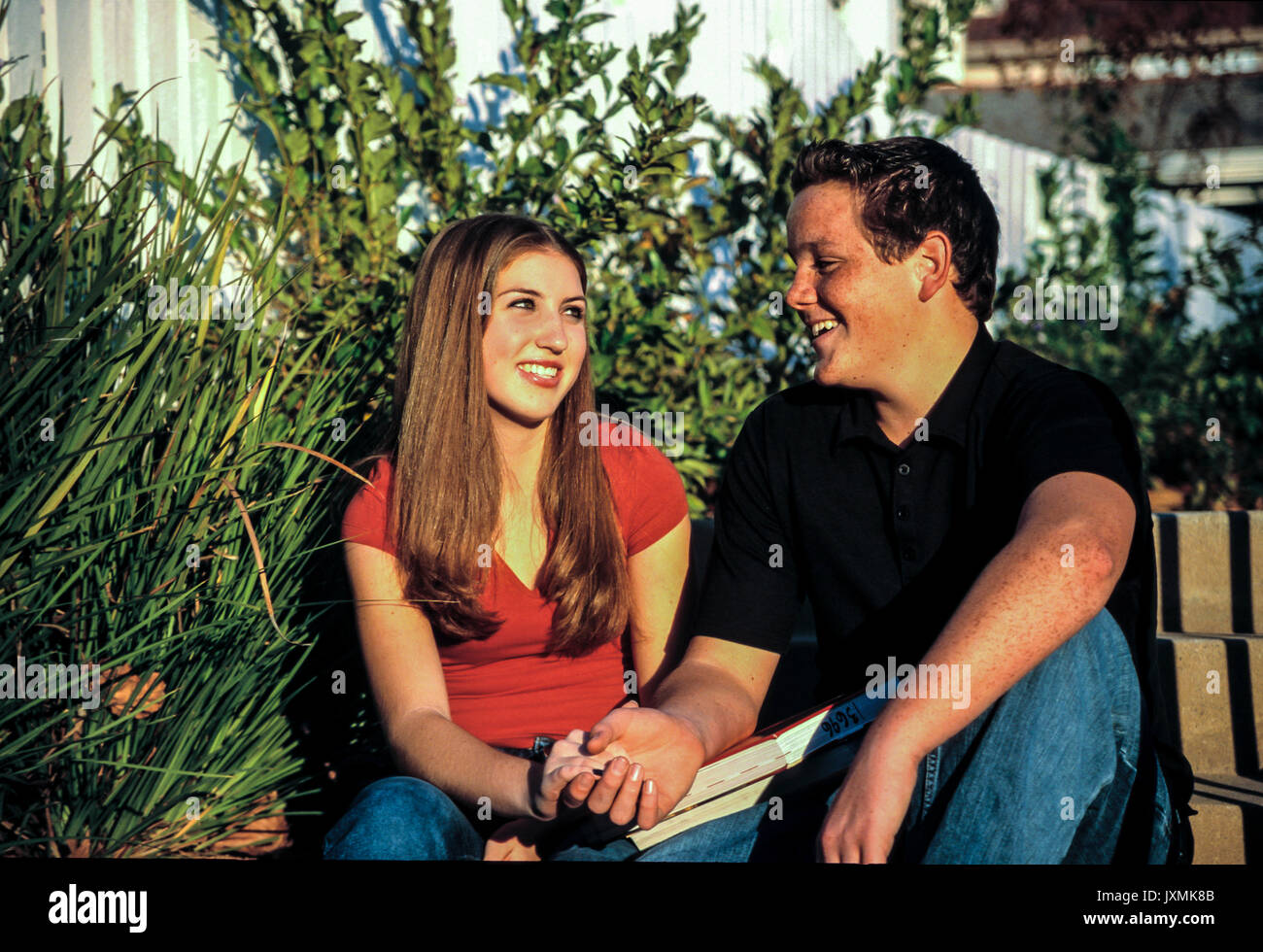 Les jeunes gens de la petite enfance jeune couple smiling at each other on en cour avant de l'école © Myrleen innocent sain Pearson Banque D'Images