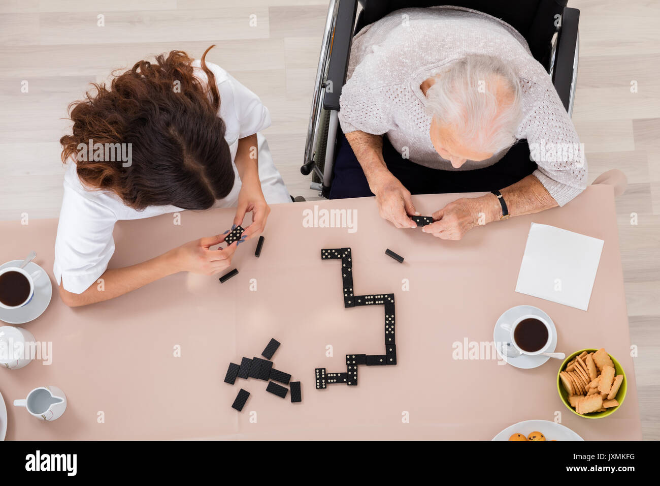Portrait de femme jouant de l'ancien jeu de domino avec son infirmière Banque D'Images