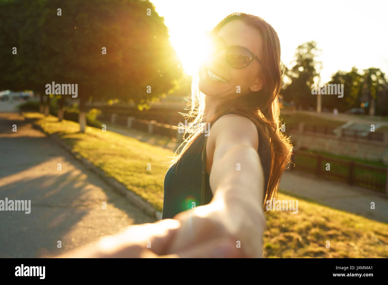 Suivez-moi - happy young woman pulling guy's hand - main dans la main marchant sur une journée ensoleillée - concept de vie moderne sans souci Banque D'Images