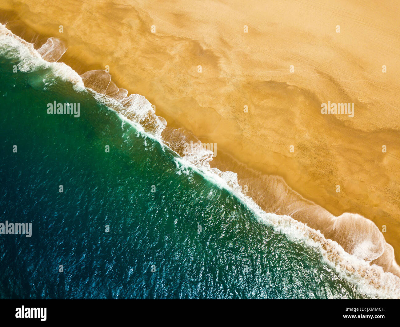 Vue de dessus d'une plage déserte. La côte portugaise de l'océan Atlantique. Drone aérien photo de vagues de l'océan pour atteindre la rive. Banque D'Images