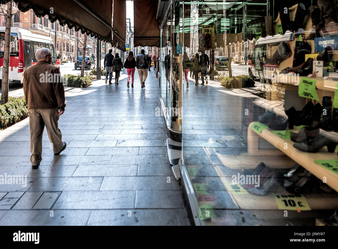 Les gens qui marchent sur la rue Gran Via et reflétée dans la vitrine de l'ancien magasin de chaussures Macias, Granada, Espagne Banque D'Images
