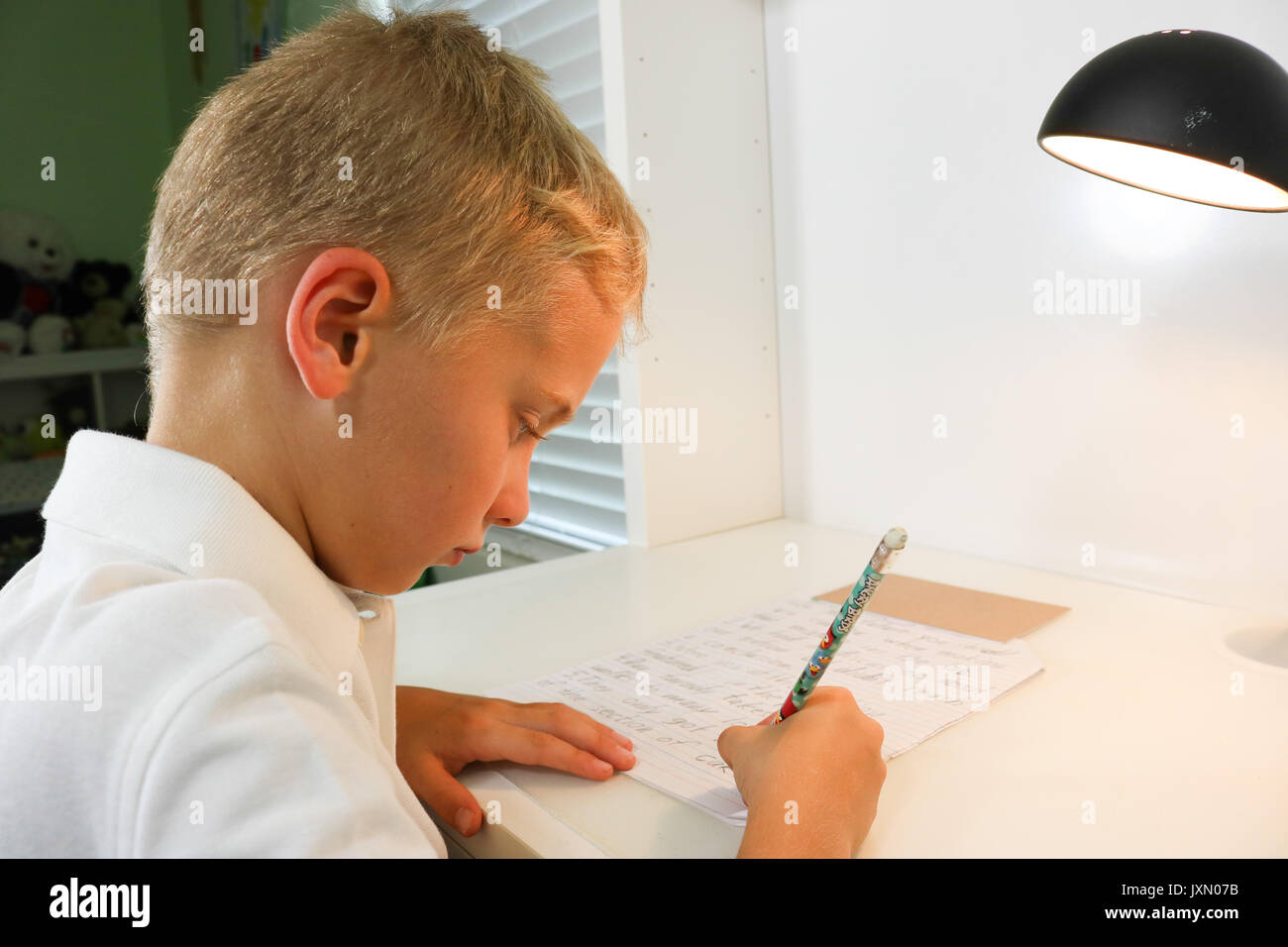 Close up portrait of a young boy doing homework écrit Banque D'Images