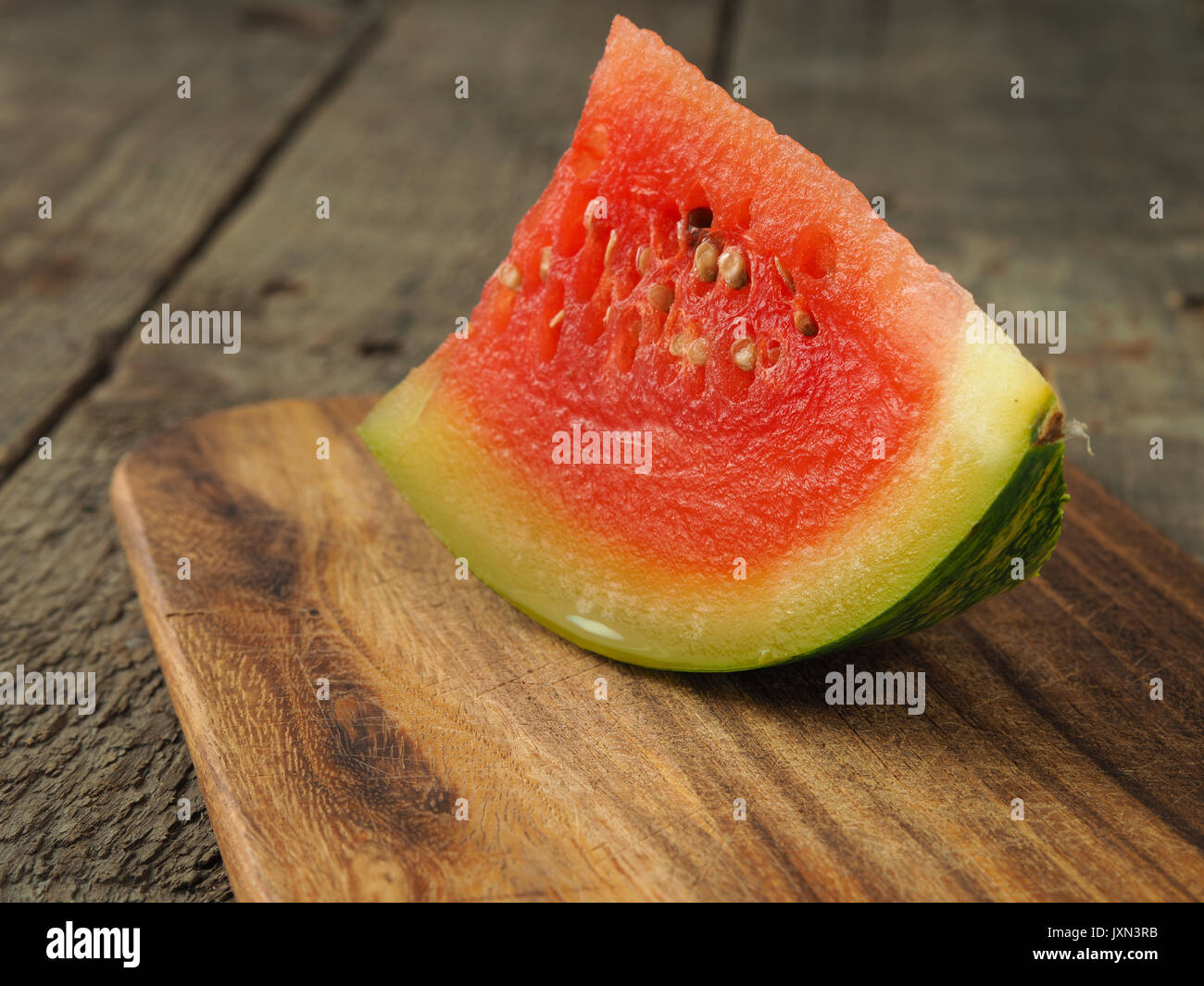 Un morceau de melon d'eau sur une planche à découper en bois Banque D'Images
