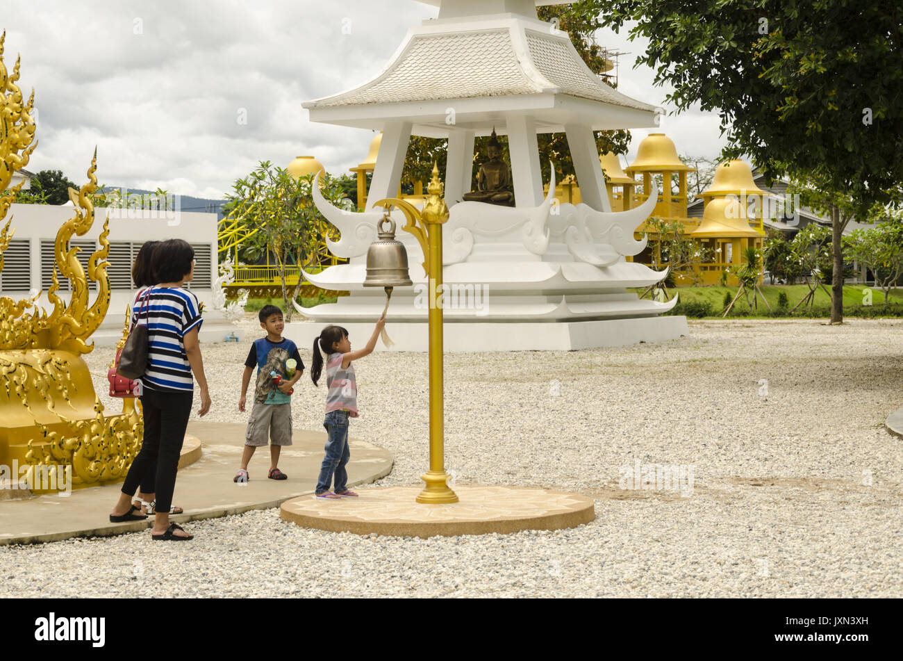 Wat Rong Khun, petite fille sonne à Bell Temple blanc, Chiang Rai, Thaïlande Banque D'Images