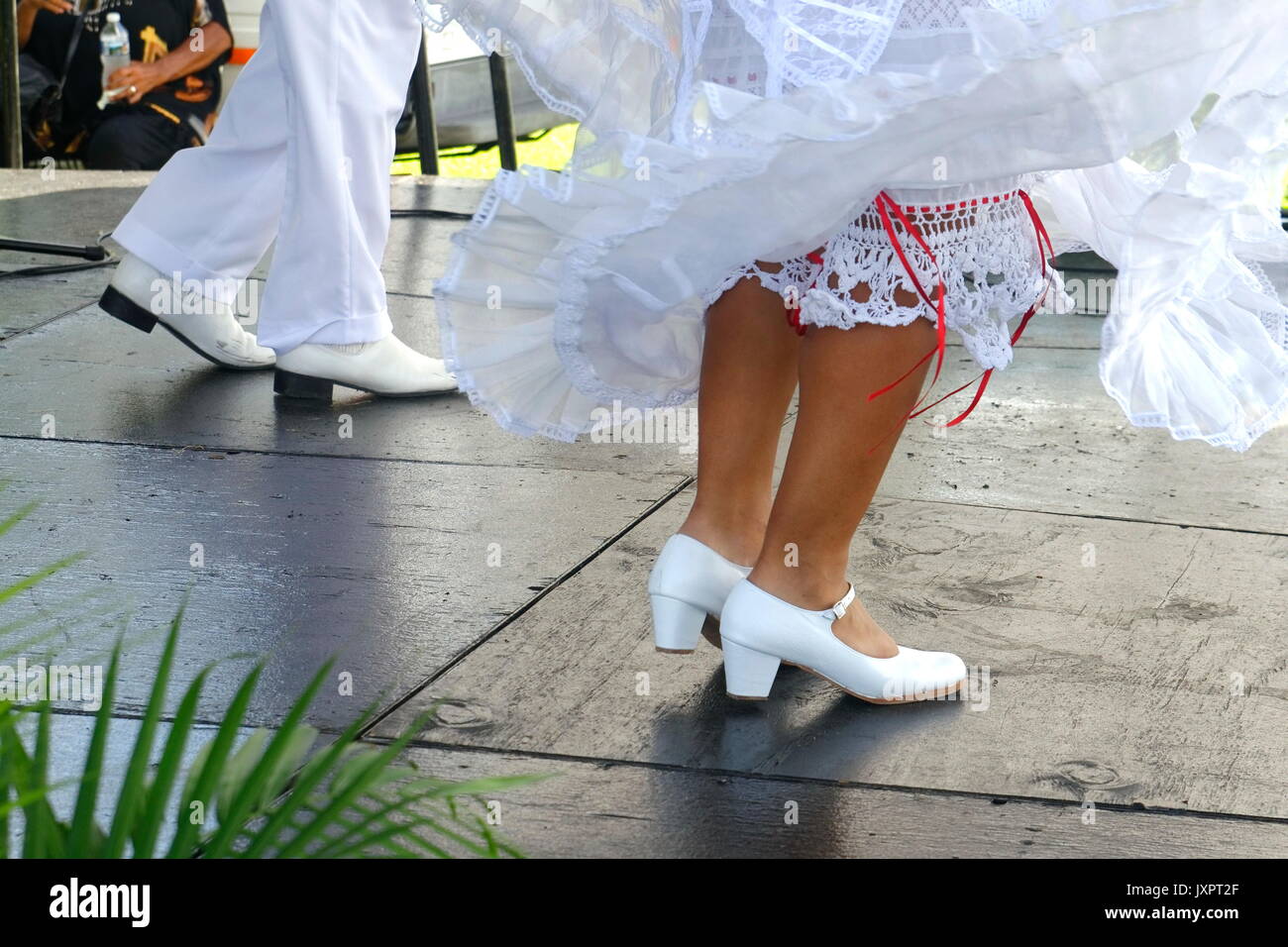Pieds de danseurs mexicains traditionnels en chaussures blanches, un mâle et une femelle, capturés à mi-pas dans une performance culturelle vibrante. Banque D'Images Pieds de danseurs mexicains traditionnels en chaussures blanches, un mâle et une femelle, capturés à mi-pas dans une performance culturelle vibrante. Banque D'Images