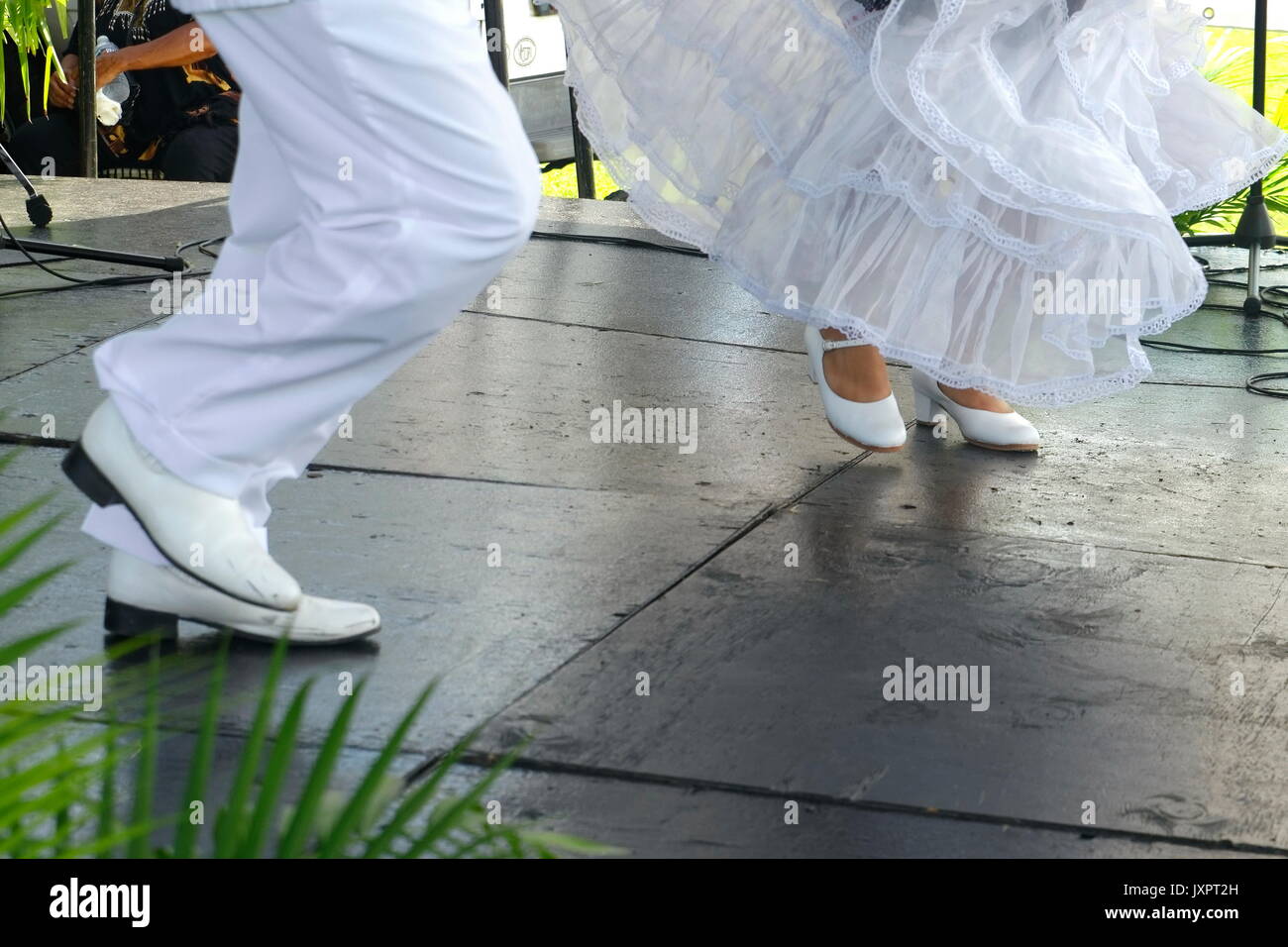 Pieds de danseurs mexicains traditionnels en chaussures blanches, un mâle et une femelle, capturés à mi-pas dans une performance culturelle vibrante. Banque D'Images Pieds de danseurs mexicains traditionnels en chaussures blanches, un mâle et une femelle, capturés à mi-pas dans une performance culturelle vibrante. Banque D'Images