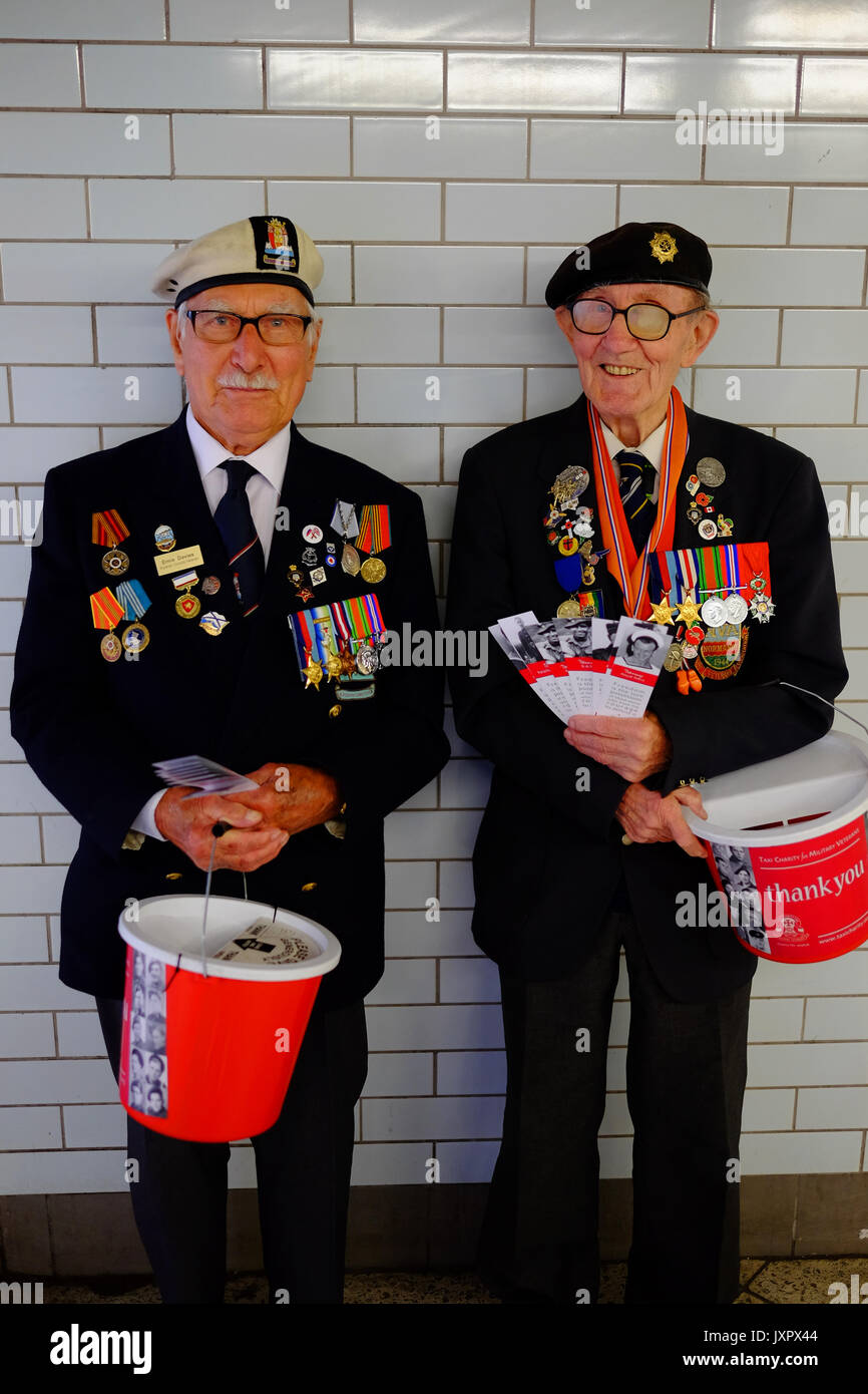Les anciens combattants de la guerre militaire et navale la collecte à Westminster tube station de taxi pour leur charité. Chacun avait un signet avec leur service photo. Banque D'Images