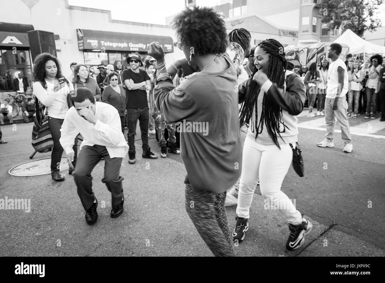 OAKLAND, CA - Aug 6, 2014 : Les gens danser dans la rue au cours de l'Art Galerie hop mensuel murmure. Foule diversifiée d'artistes et les gens branchés. Monochrome. Banque D'Images