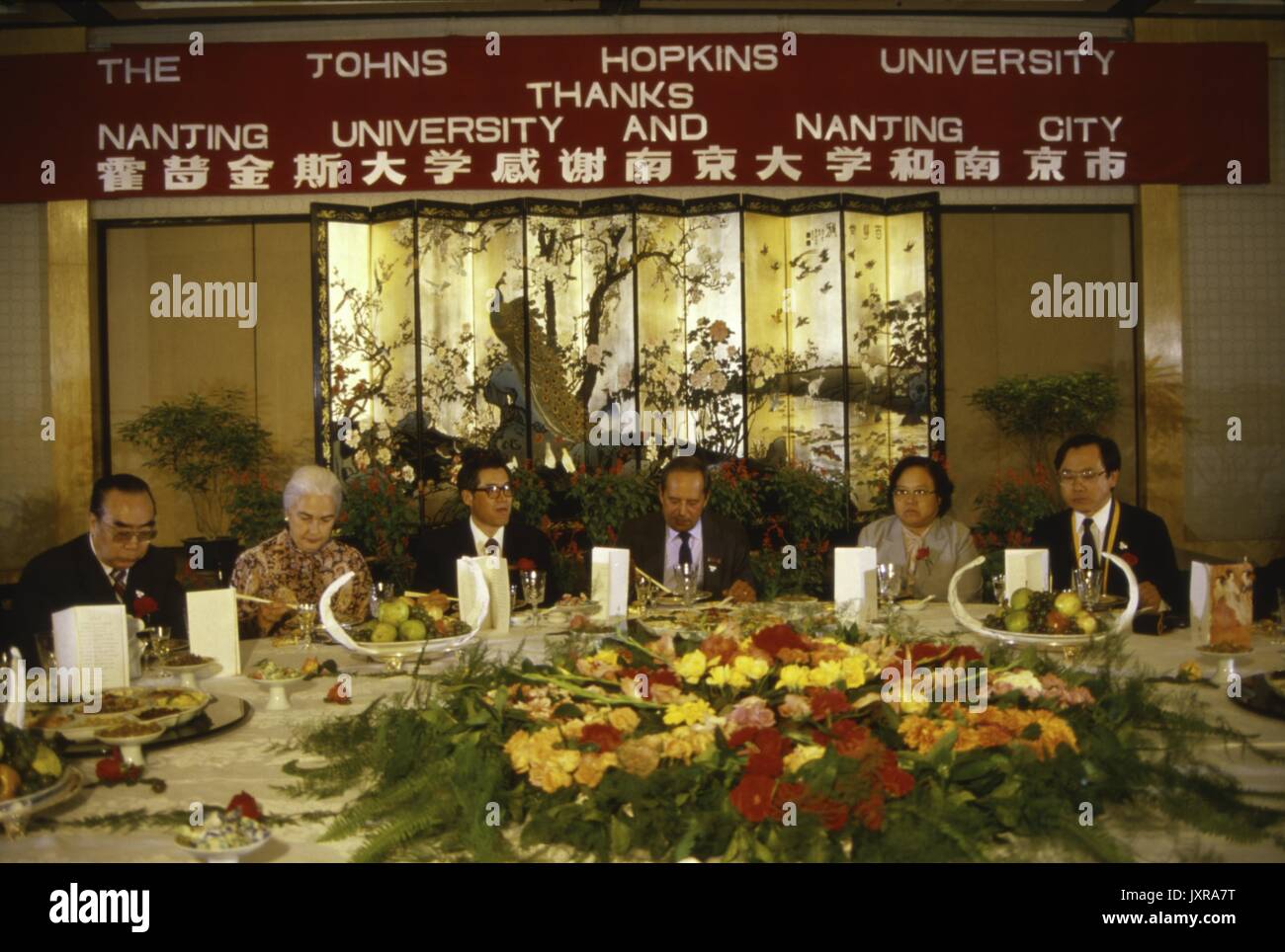 Centre de Nanjing, l'ISC, délégation des représentants de l'Université Hopkins banqueting sous une bannière pour le Centre de Nanjing, 1986. Banque D'Images