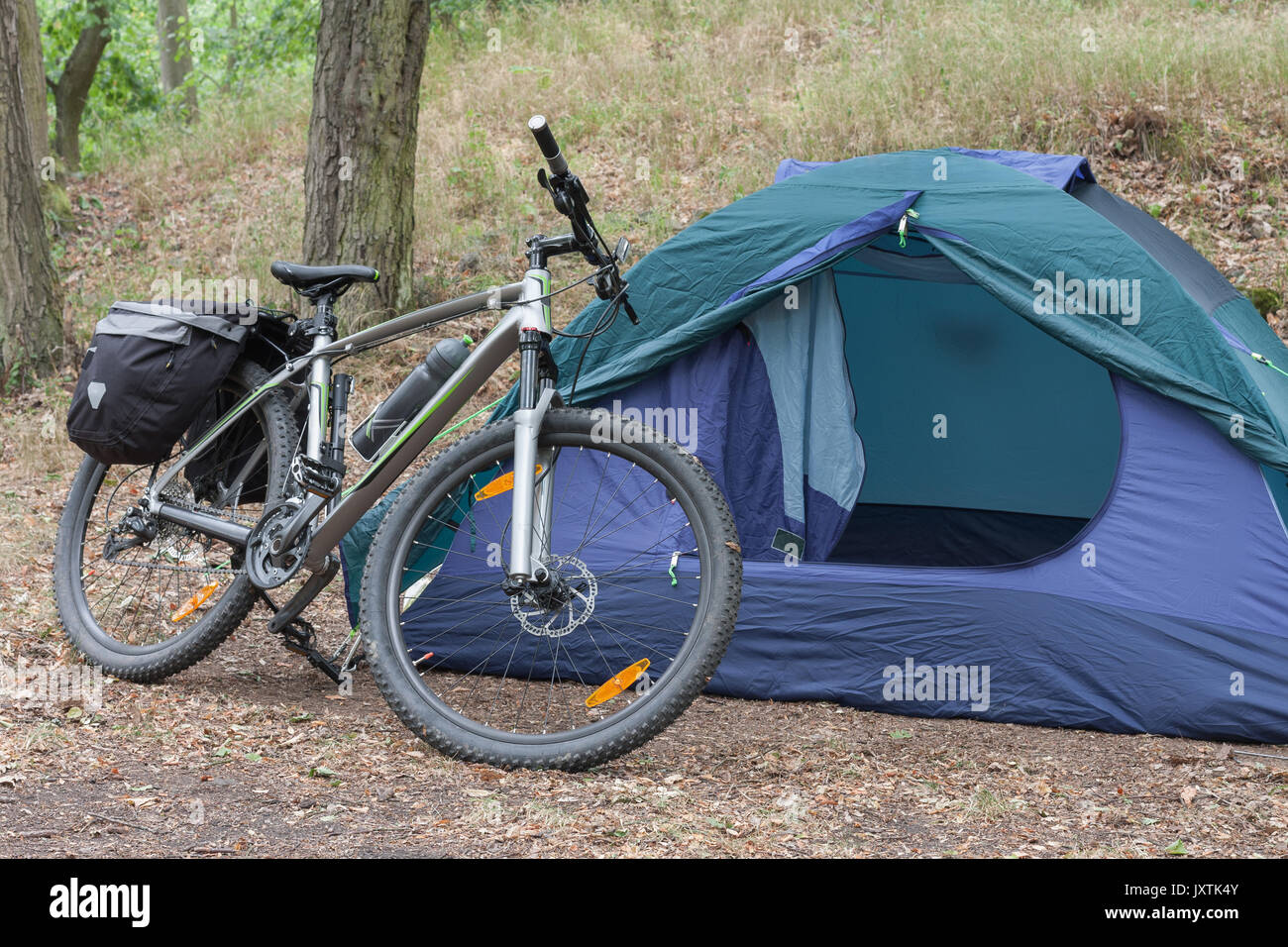 Avec les sacoches de vélo de montagne en face de tente dans les bois dans  le matin d'été . Équipements de camping est monté sur le vélo Photo Stock -  Alamy