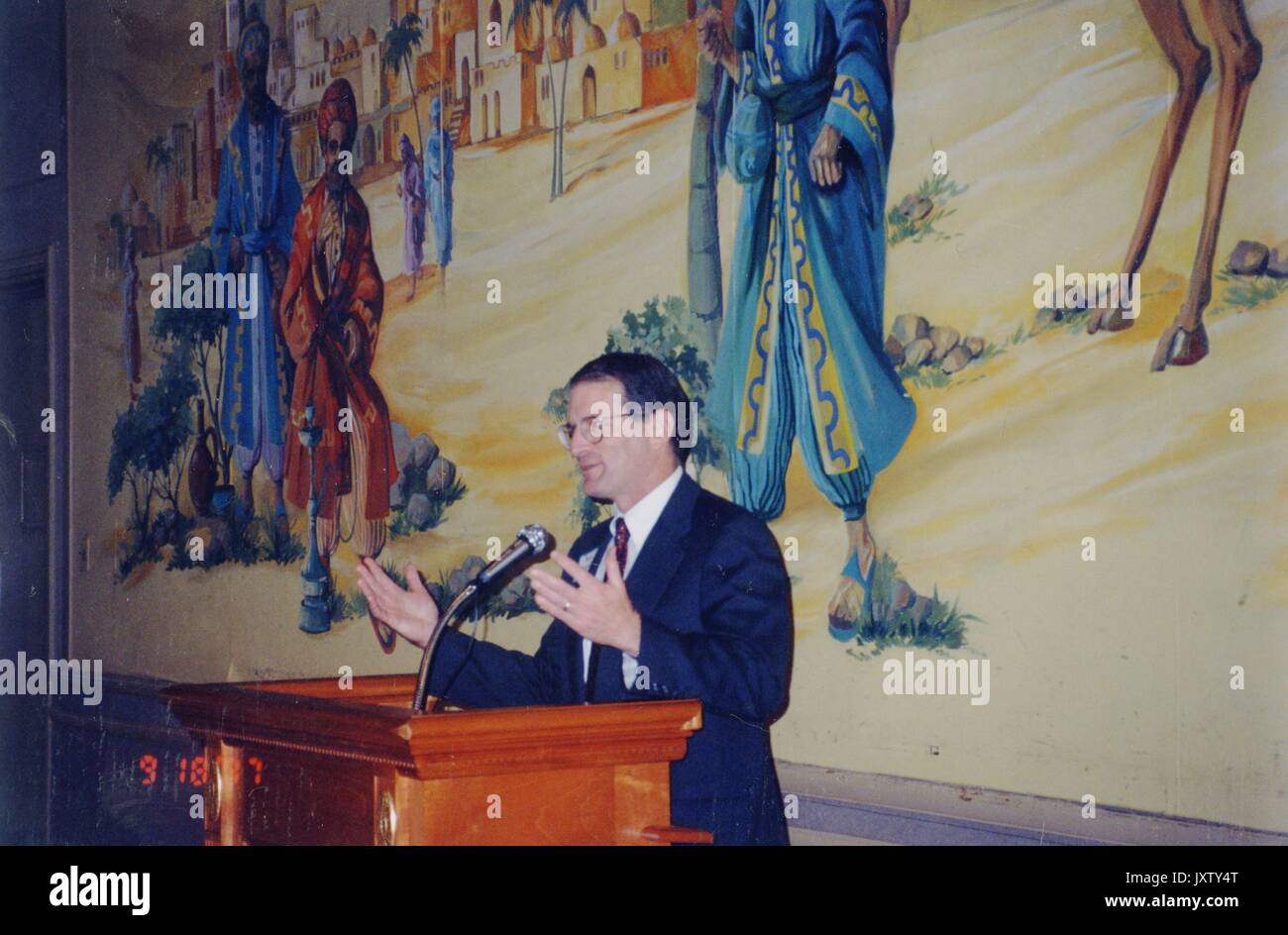 William Ralph Brody, debout sur l'estrade en donnant la parole, vue de côté, jusqu'à la taille, 1997. Banque D'Images