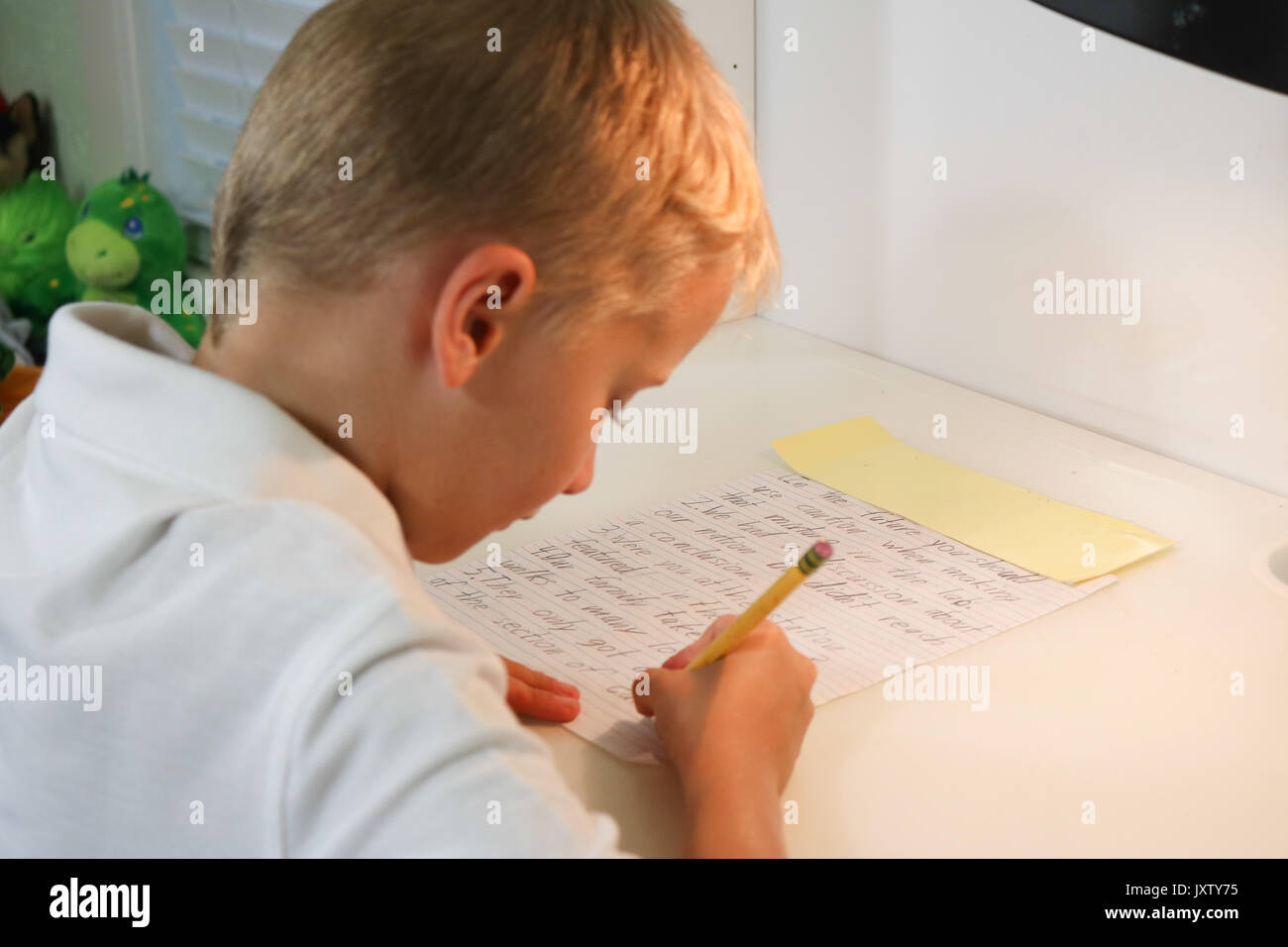 Close up portrait of a young boy doing homework écrit dans selective focus Banque D'Images