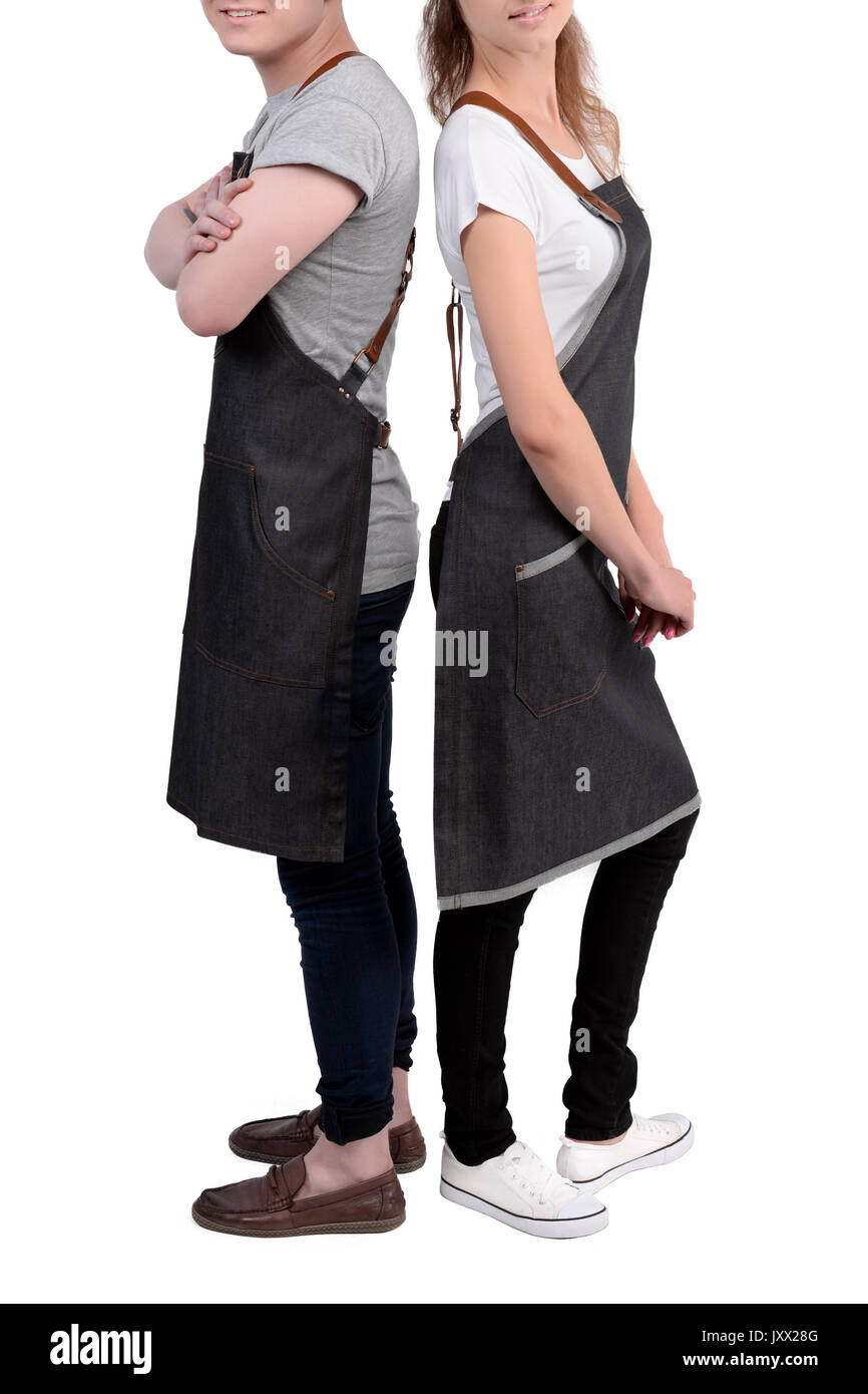 Jeunes chefs ou maîtres d'homme et de la femme pose, portant des tabliers isolé sur fond blanc. Café café barista uniforme. Banque D'Images
