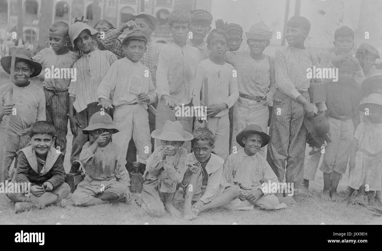 Photo de paysage pleine longueur de jeunes garçons vêtus de chapeaux et de vêtements décontractés, certains Afro-américains, tous avec des expressions souriantes, 1915. Banque D'Images
