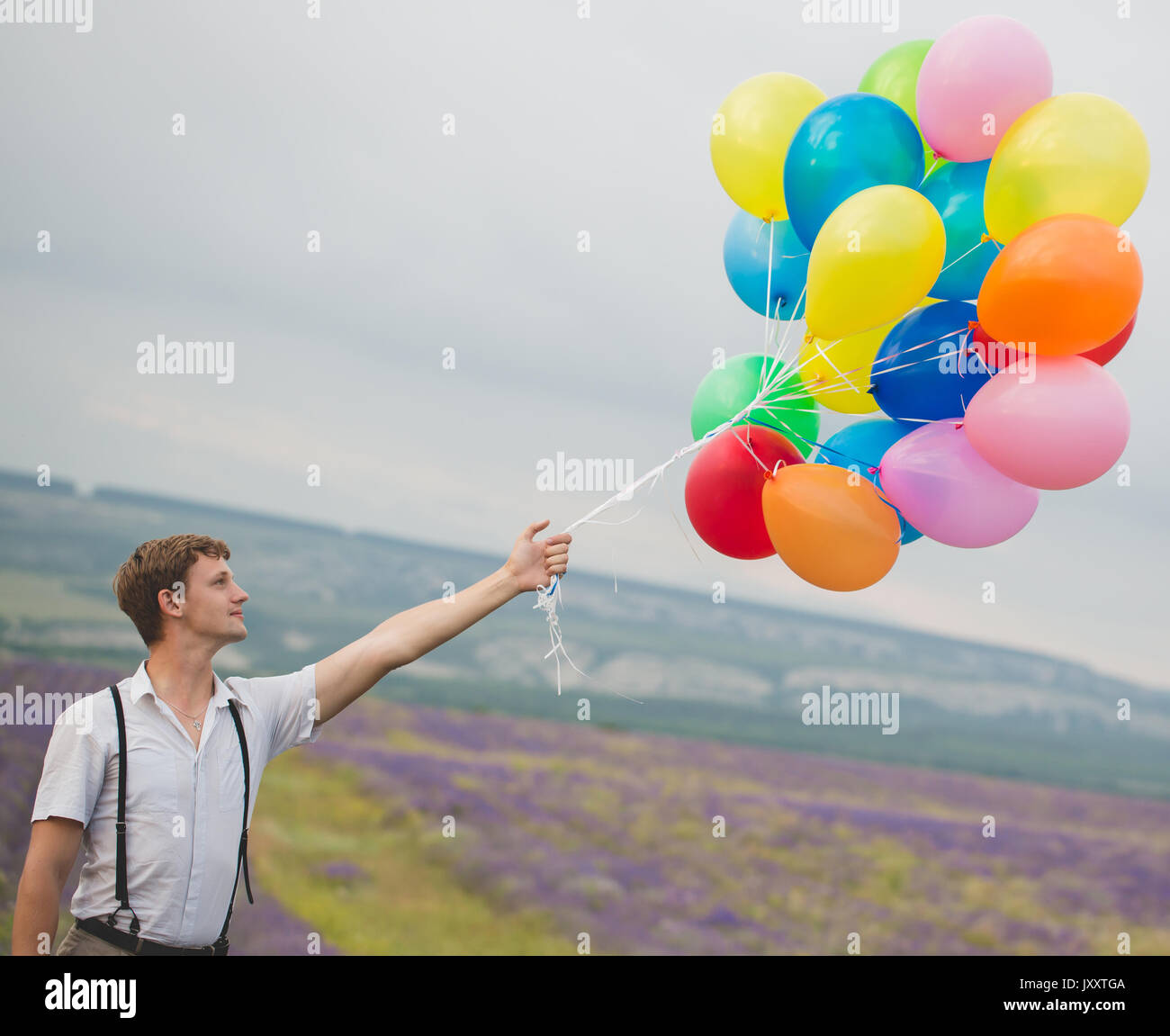 Young man holding bouquet de ballons colorefull Banque D'Images