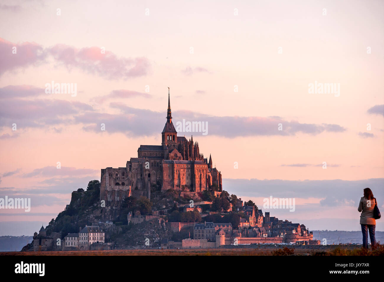 Le Mont Saint-Michel (Saint Michael's Mount) avant la construction de la passerelle avec une jeune femme au premier plan. Soleil levant, 2011 Banque D'Images