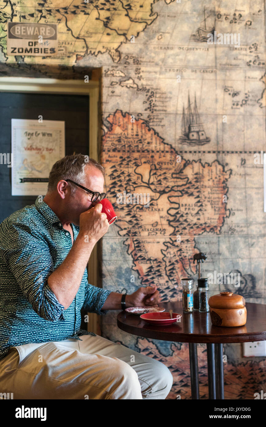 L'homme de boire du café dans le monocle et sirène en Simon's Town, Cape Town. Banque D'Images