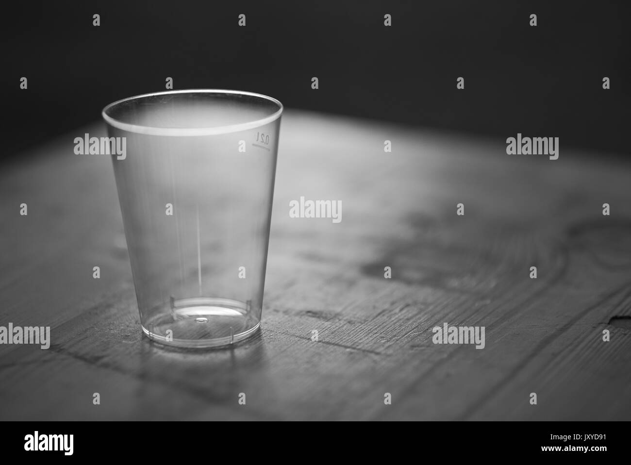 Tasse en plastique rétroéclairé propre vide sur une table de nuit en bois libre Banque D'Images