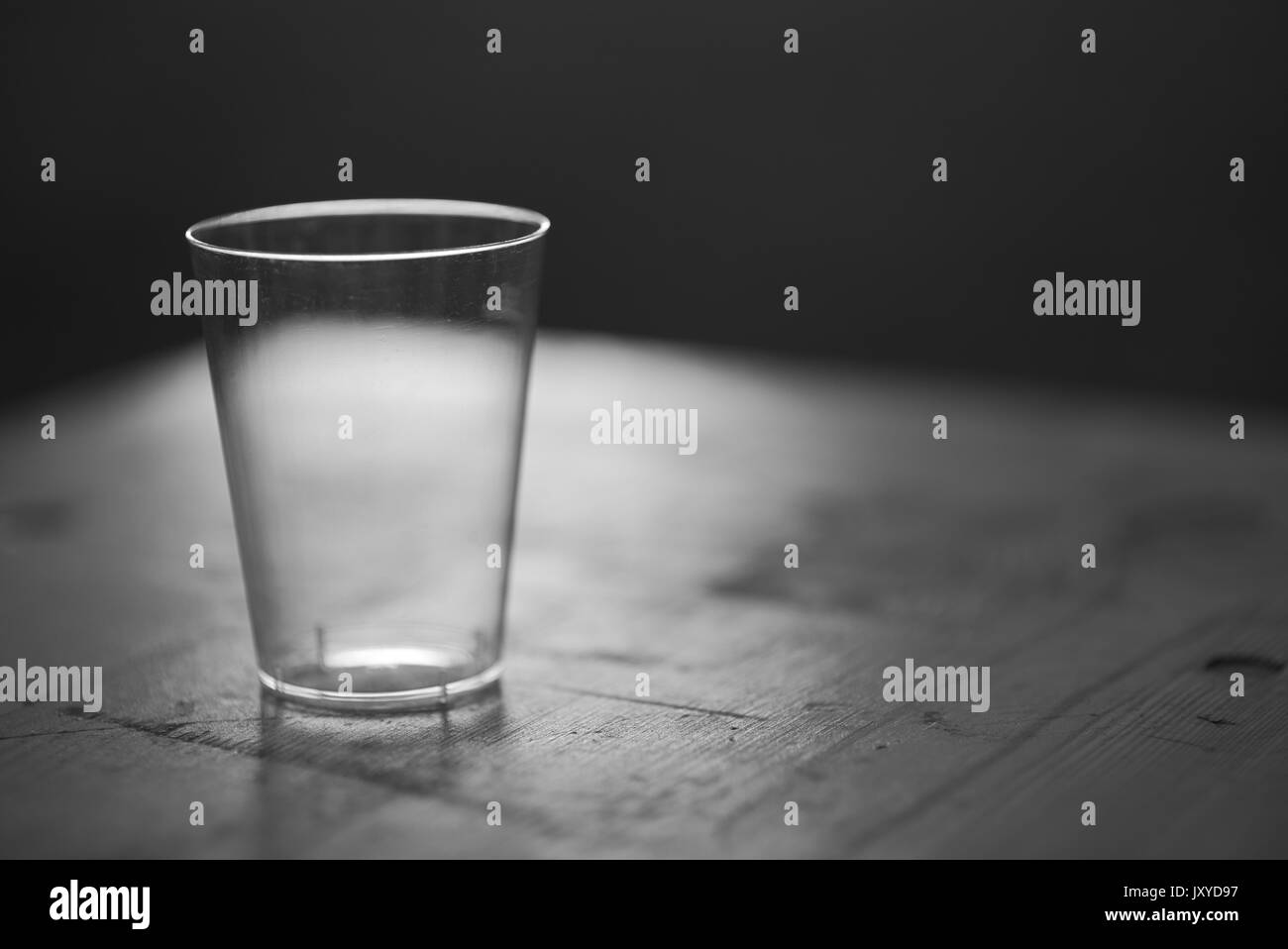 Tasse en plastique rétroéclairé propre vide sur une table de nuit en bois libre Banque D'Images