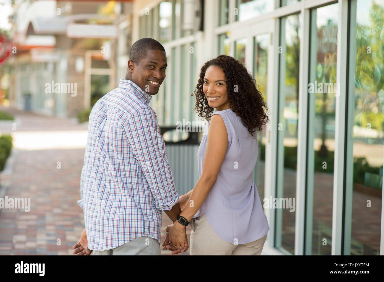 Portrait of smiling couple holding hands and looking at camera Banque D'Images