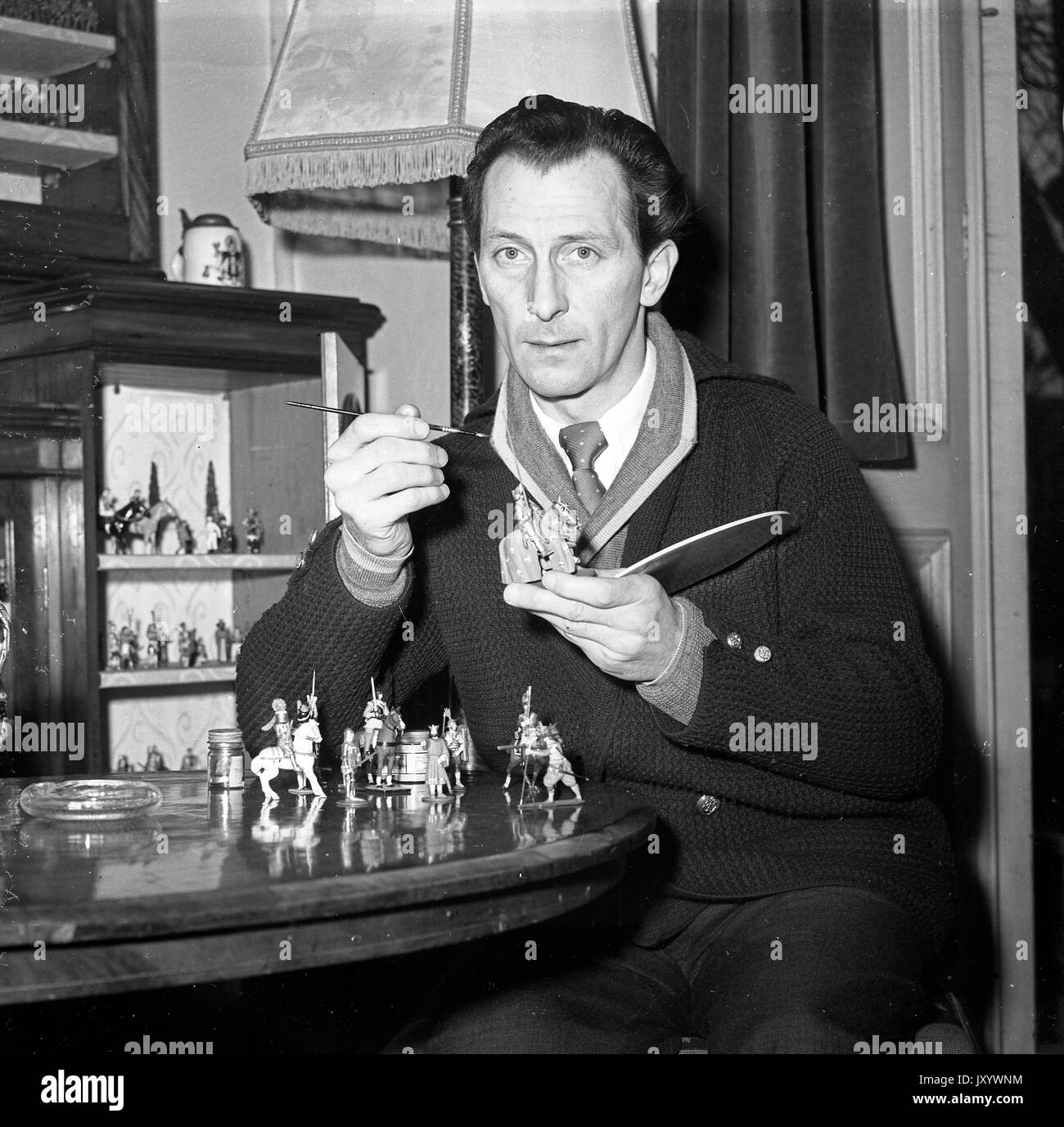 Acteur du film Peter Cushing peindre ses petits soldats à son domicile en 1956 Banque D'Images