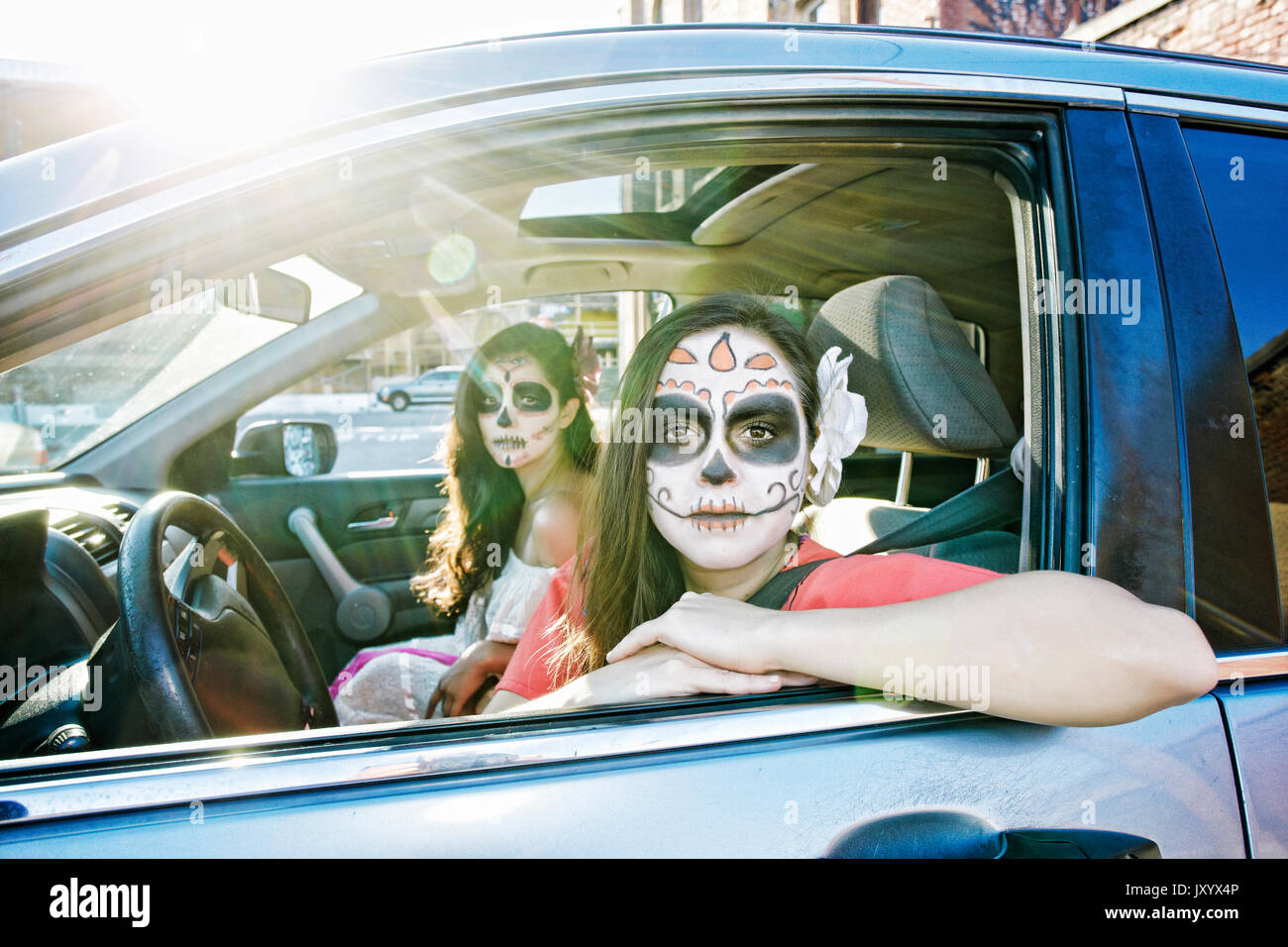 Les femmes en voiture portant crâne face paint Banque D'Images