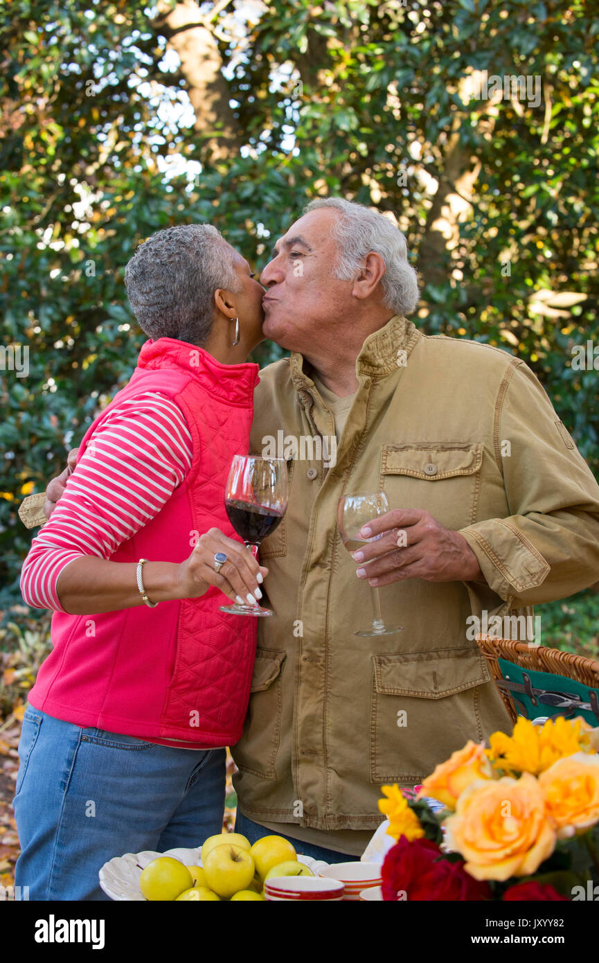 Couple drinking wine et les baisers à l'extérieur Banque D'Images