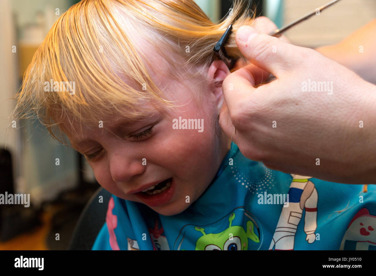 Portrait Bebe Garcon S Assied Et Pleure Pendant Qu Il Se Fait Couper Les Cheveux Photo Stock Alamy