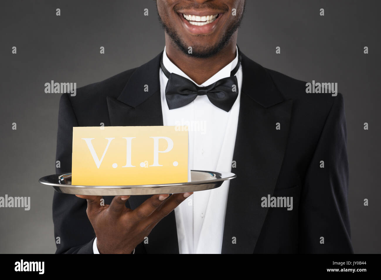 Portrait Of Happy Waiter Serving Meal en cloche Banque D'Images