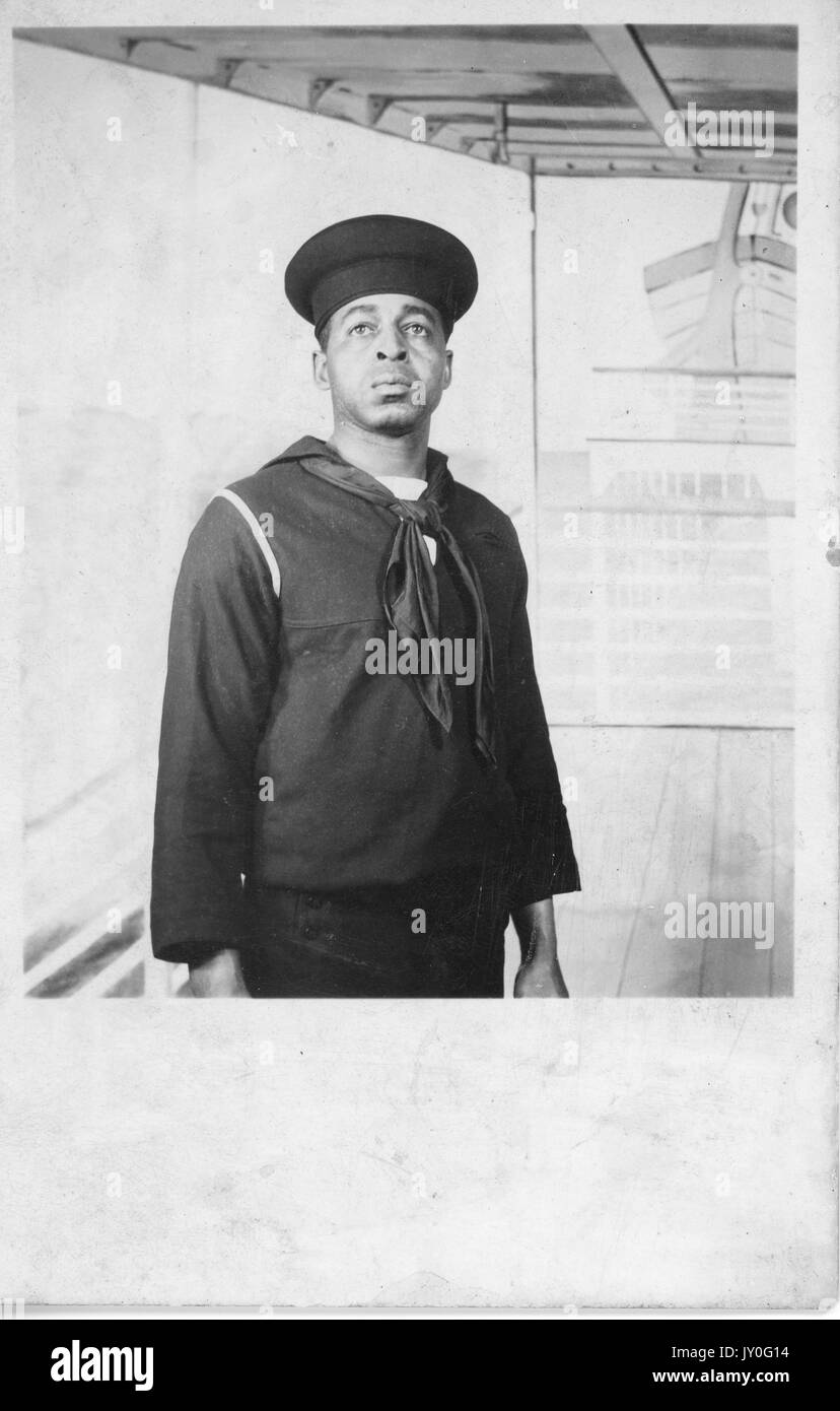 Portrait debout en demi-longueur de jeune Afro-américain d'expression neutre, habillé en tenue de marin, 1920. Banque D'Images