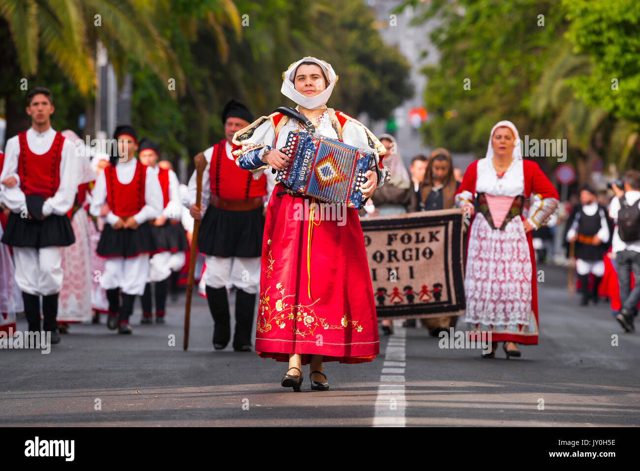 Fête traditionnelle de la Sardaigne, un accordéoniste femelle entraîne ses groupe folklorique local dans la grande procession de la Cavalcata festival à Sassari. Banque D'Images