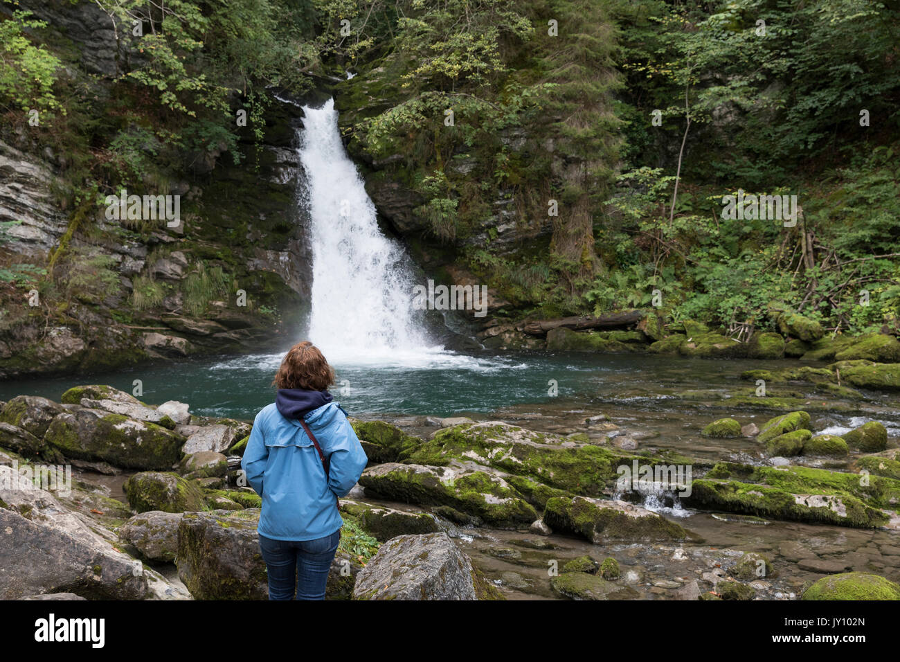 Caucasian woman admiring cascade lointain Banque D'Images