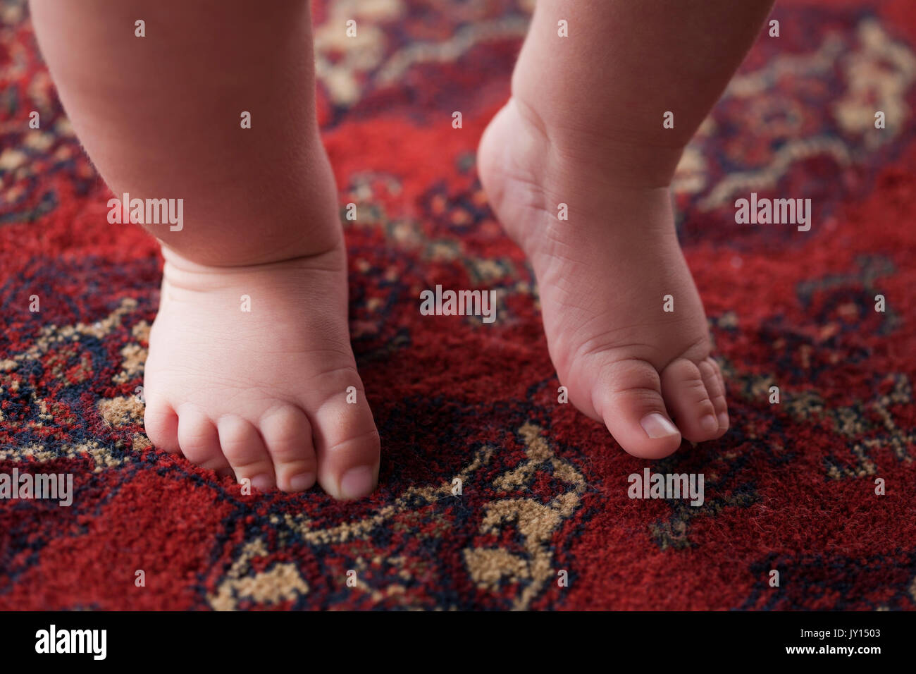 Pieds de Hispanic baby boy sur tapis Banque D'Images
