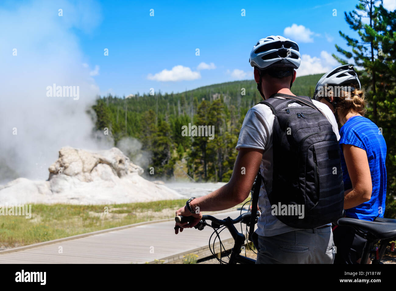 Un couple de motards, cyclistes en regardant un geyser dans le parc national de Yellowstone Banque D'Images