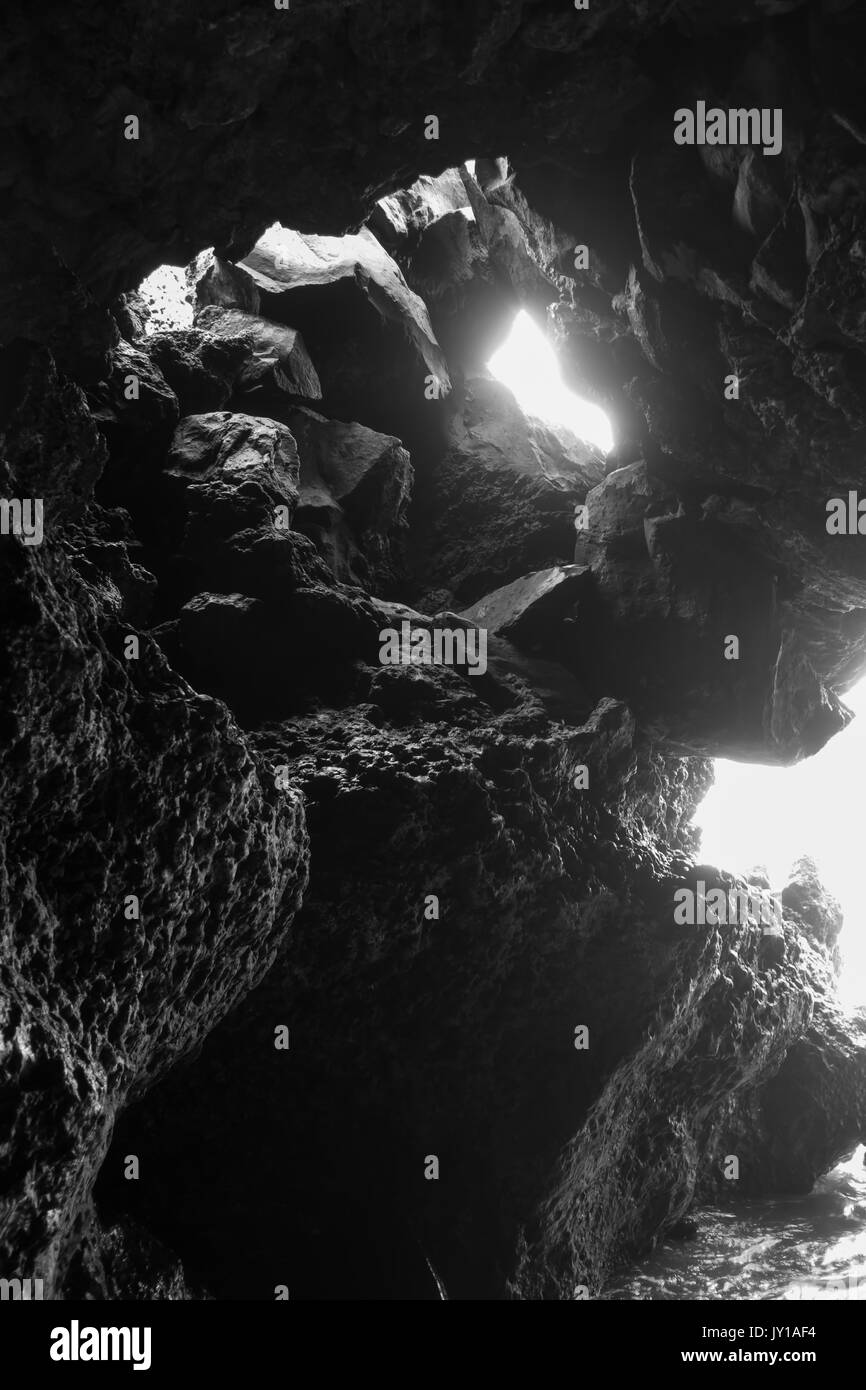 La lumière blanche brille dans une grotte marine sur l'île de Maui, Hawaii. Image en noir et blanc. Banque D'Images