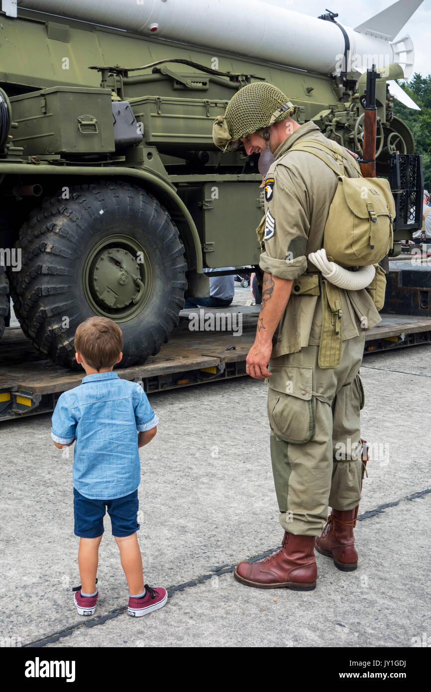 Petit garçon et WW2 reenactor nous en tenue de soldat à la recherche de missiles au chariot à la Seconde Guerre mondiale militaria juste Banque D'Images