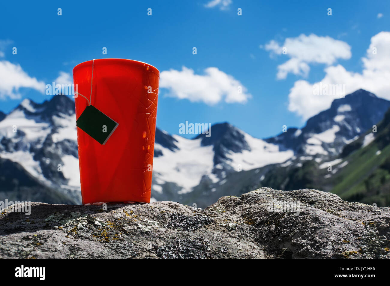 Une tasse en plastique avec un sachet de thé sur l'arrière-plan de belles montagnes debout sur la pierre. Romance de l'état sauvage. Banque D'Images