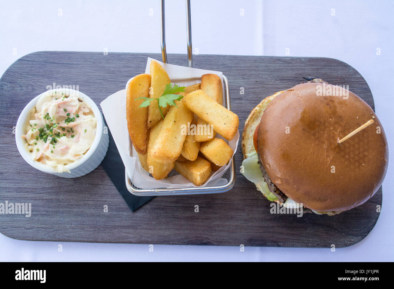 Burger, frites dans un panier et de choux servi sur une ardoise noire dans un restaurant en Espagne Banque D'Images