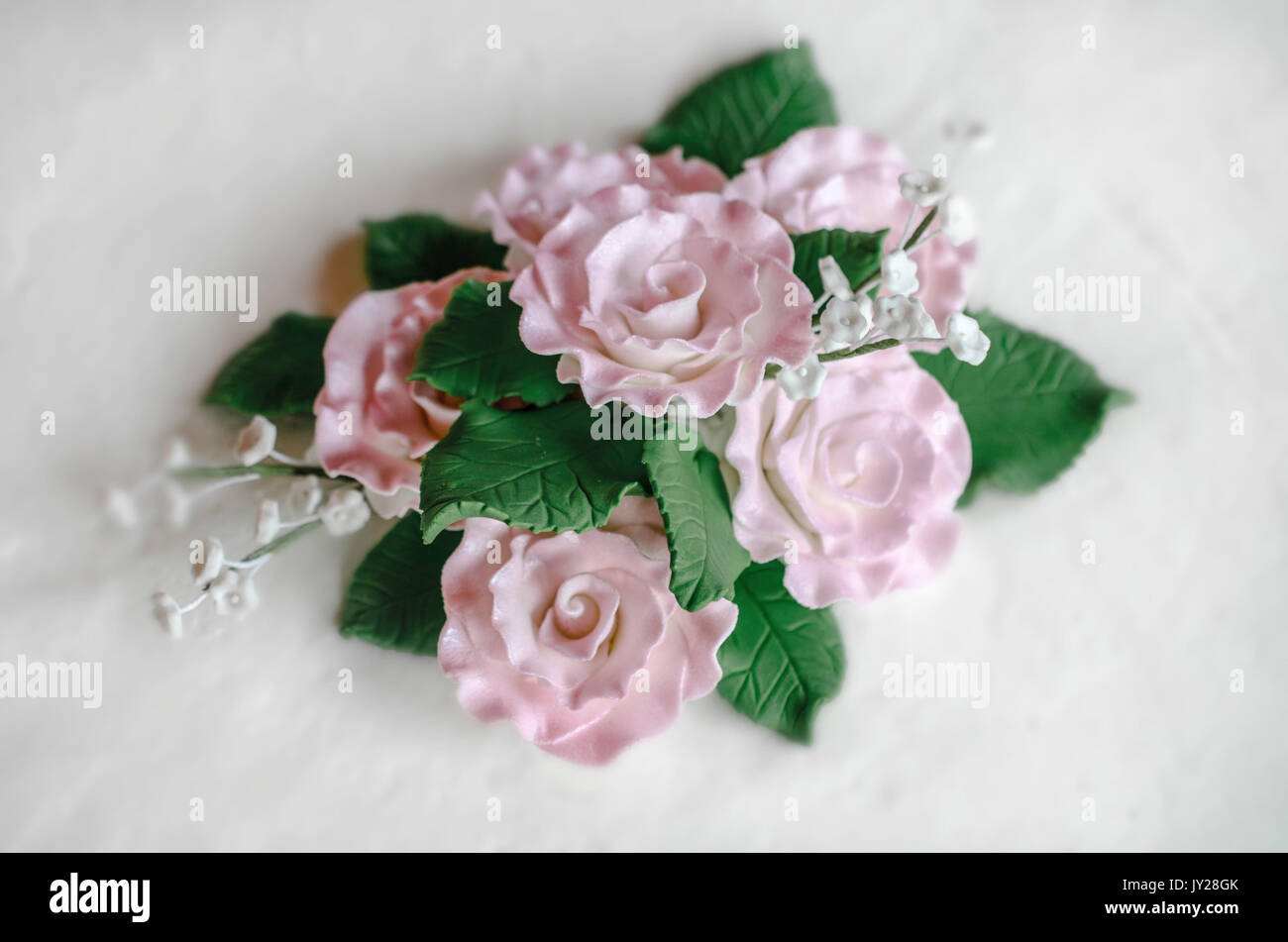 Du fondant en forme de fleurs roses et feuilles vert Banque D'Images