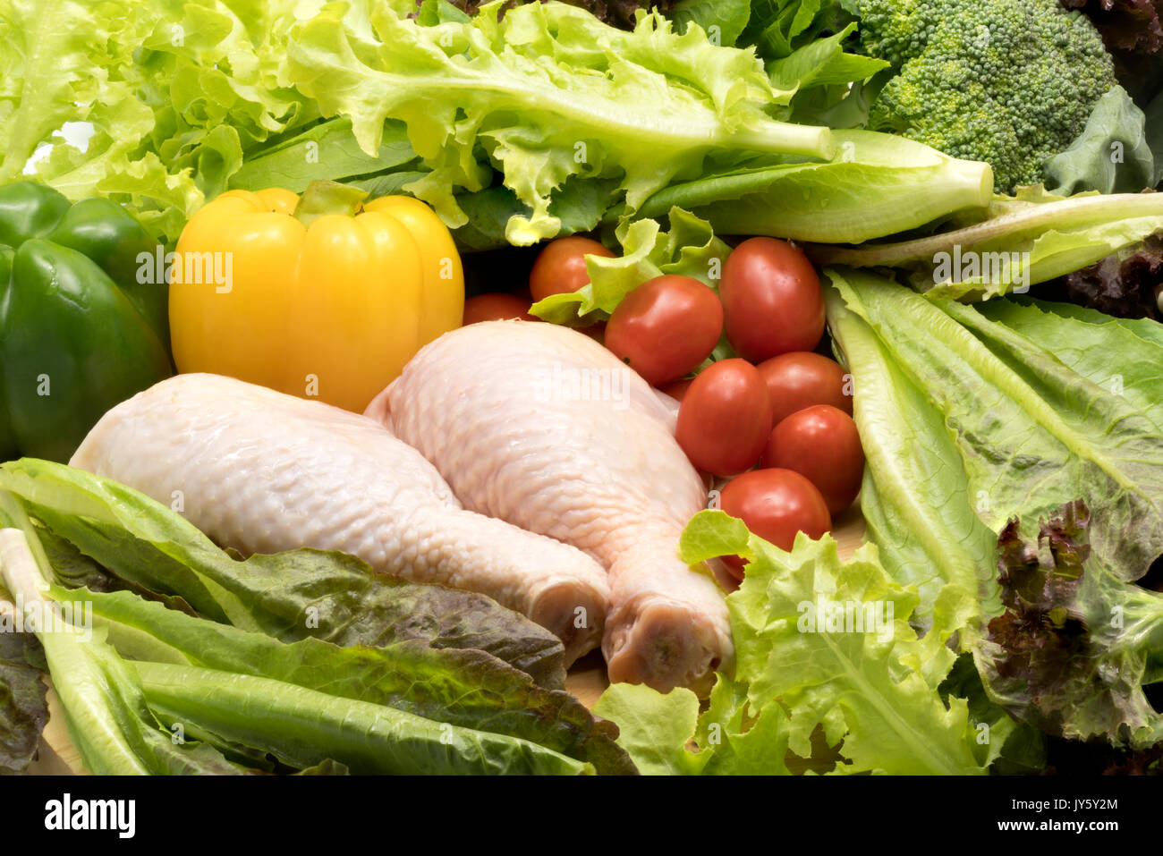 Poulet frais cru et différents types de légumes sur un table en bois Banque D'Images