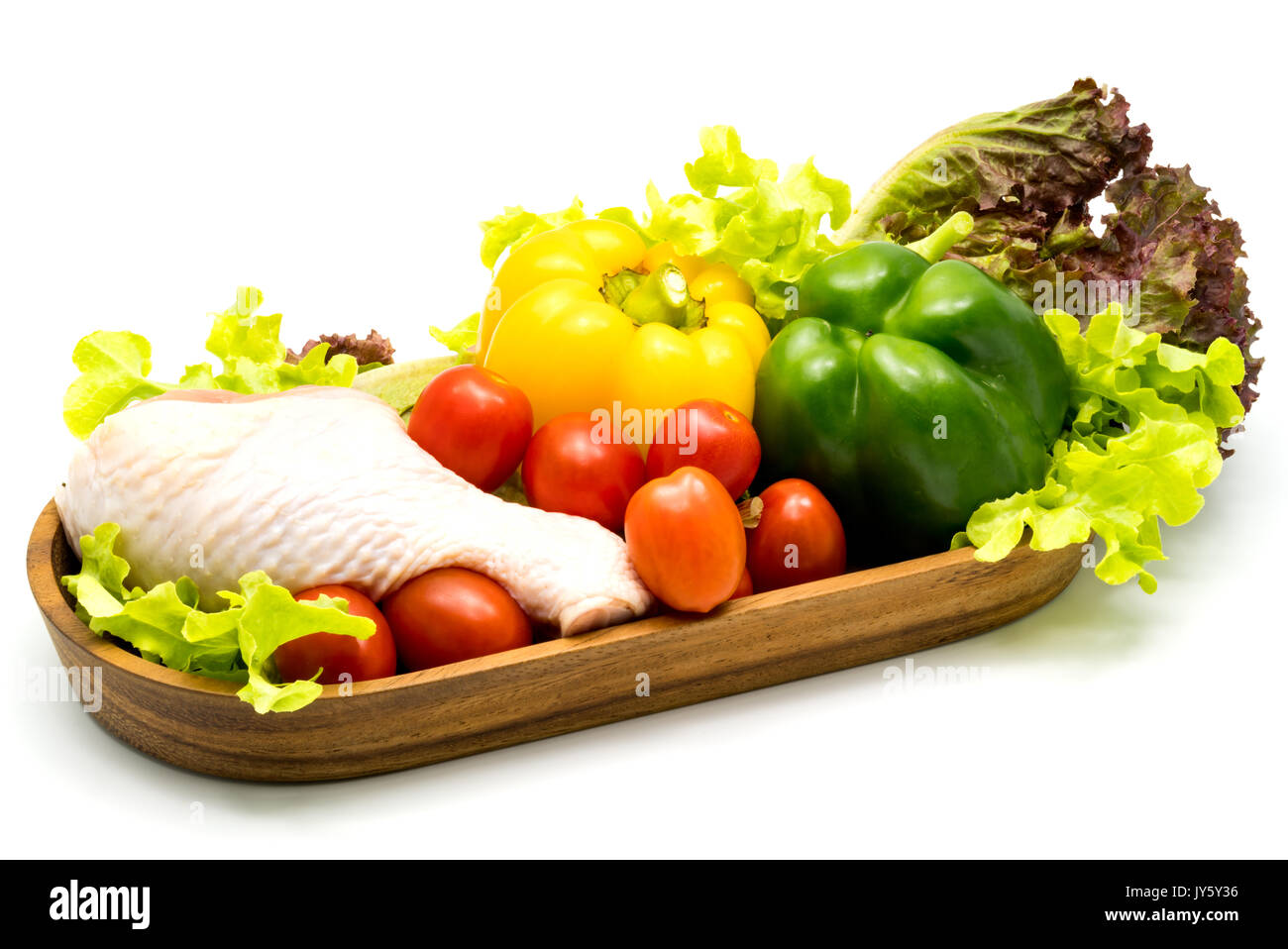Faire briller le poulet et les légumes crus dans un plateau en bois sur fond blanc Banque D'Images
