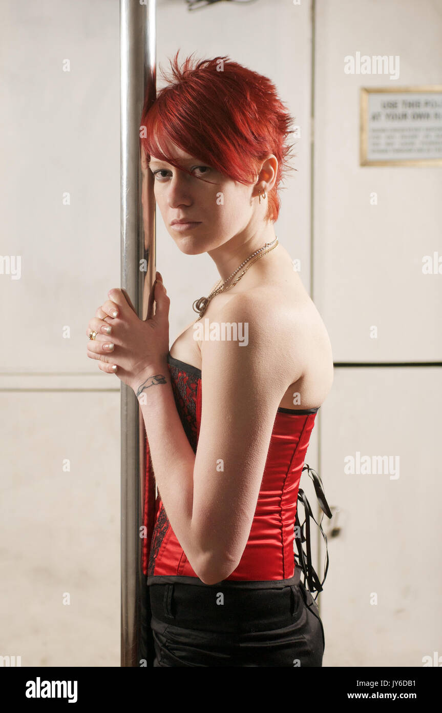 À tête rouge aux cheveux courts portant une fille jupe noire et un corset  rouge Photo Stock - Alamy