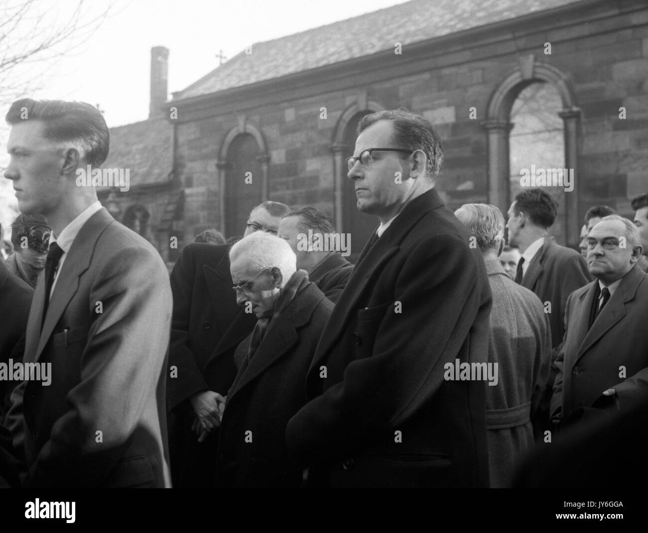 Harold Hardman (centre), président de Manchester United, s'incline la tête, avec l'Angleterre comme manager de l'équipe Walter Winterbottom (r), il pleure à l'enterrement de Manchester United le capitaine Roger Byrne à l'église paroissiale de Flixton, près de Manchester. Byrne a été l'un des joueurs tués dans la catastrophe aérienne de Munich. Banque D'Images