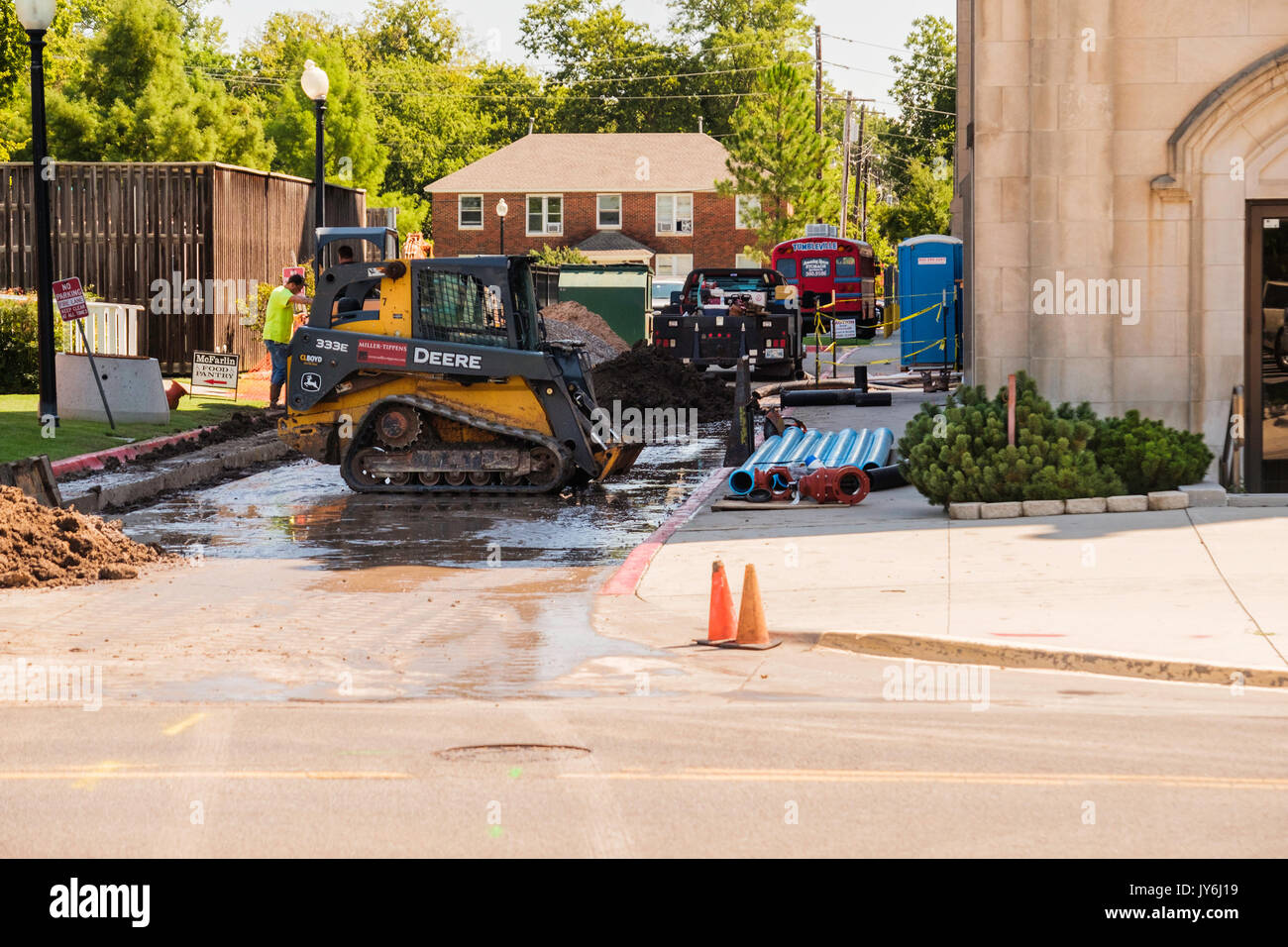 Deux ouvriers l'exploitation d'engins de terrassement construction faire la réparation dans une ruelle à Norman, Oklahoma, USA. Banque D'Images