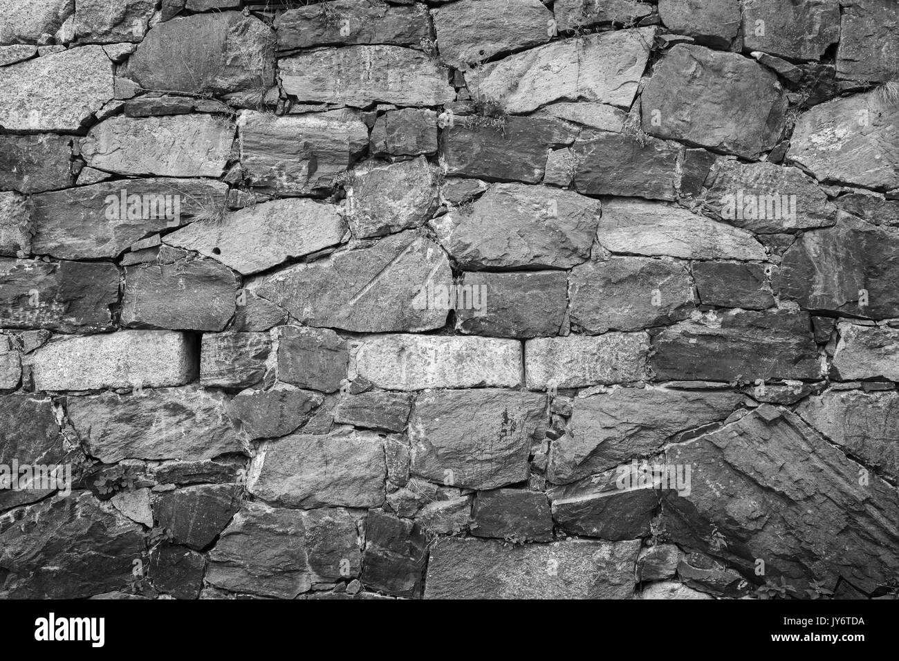 Close-up d'un vieux mur à une forteresse faite de pierres en noir et blanc avec le vignetage. Banque D'Images