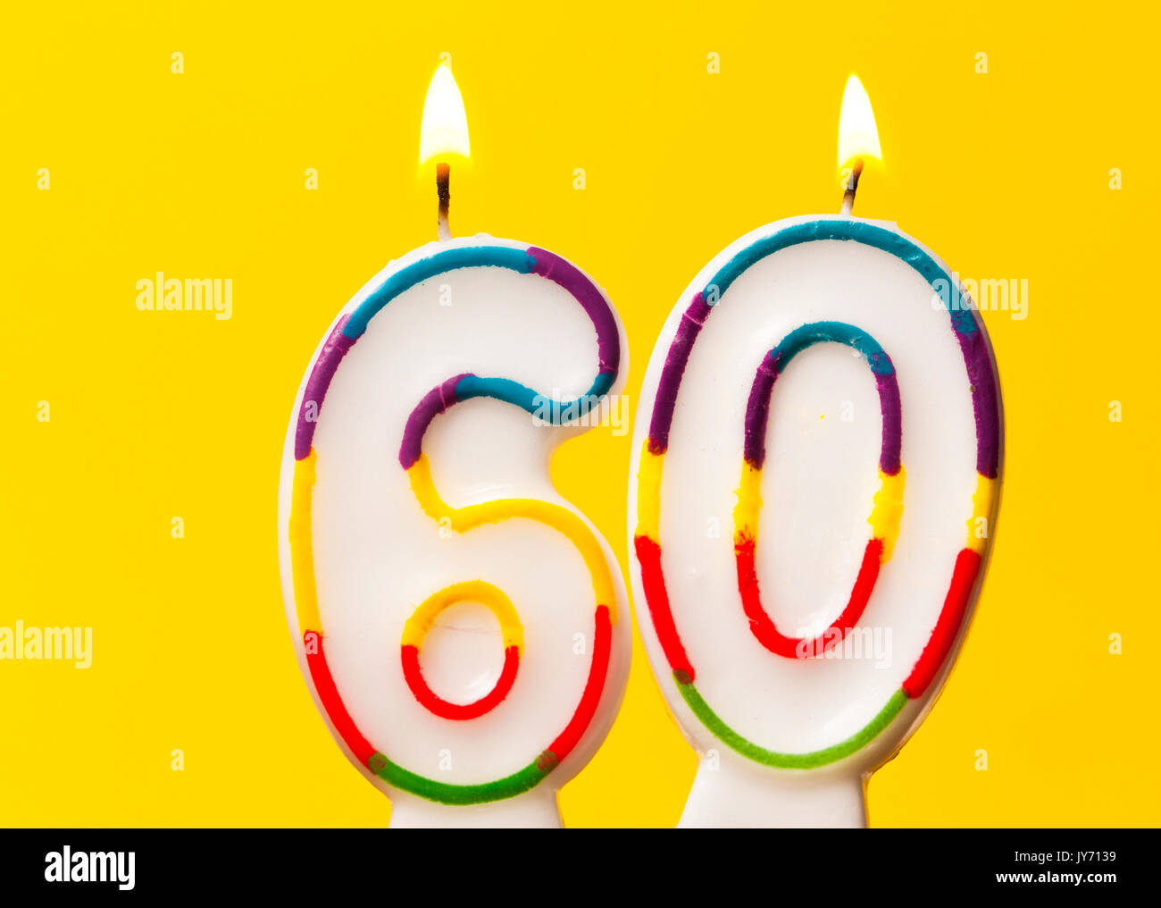 Bougie célébration de l'anniversaire de numéro 60 contre un arrière-plan jaune vif Banque D'Images