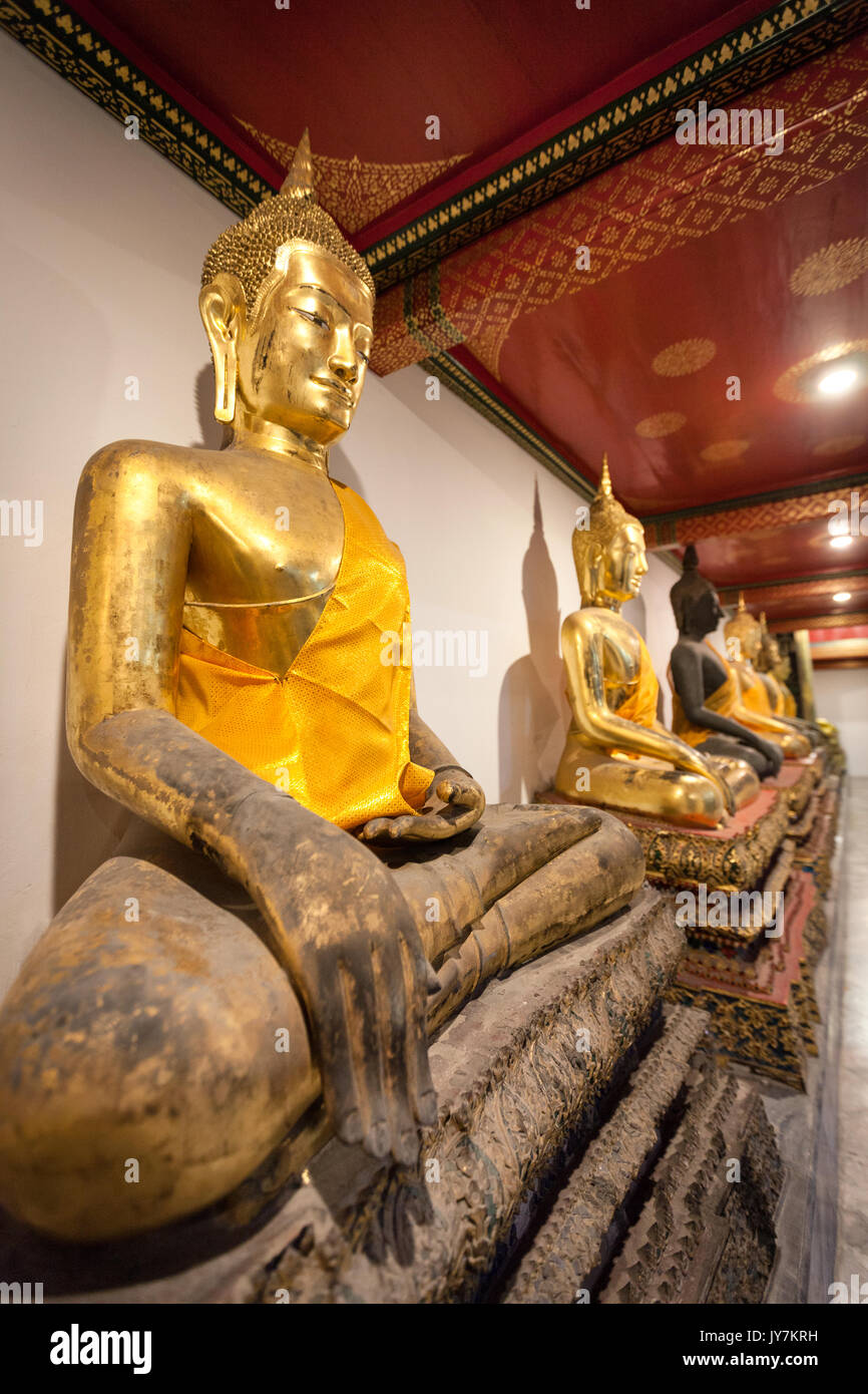 Rangée de bouddhas assis d'or priant au Wat Pho (Temple du Bouddha couché), Bangkok, Thaïlande Banque D'Images