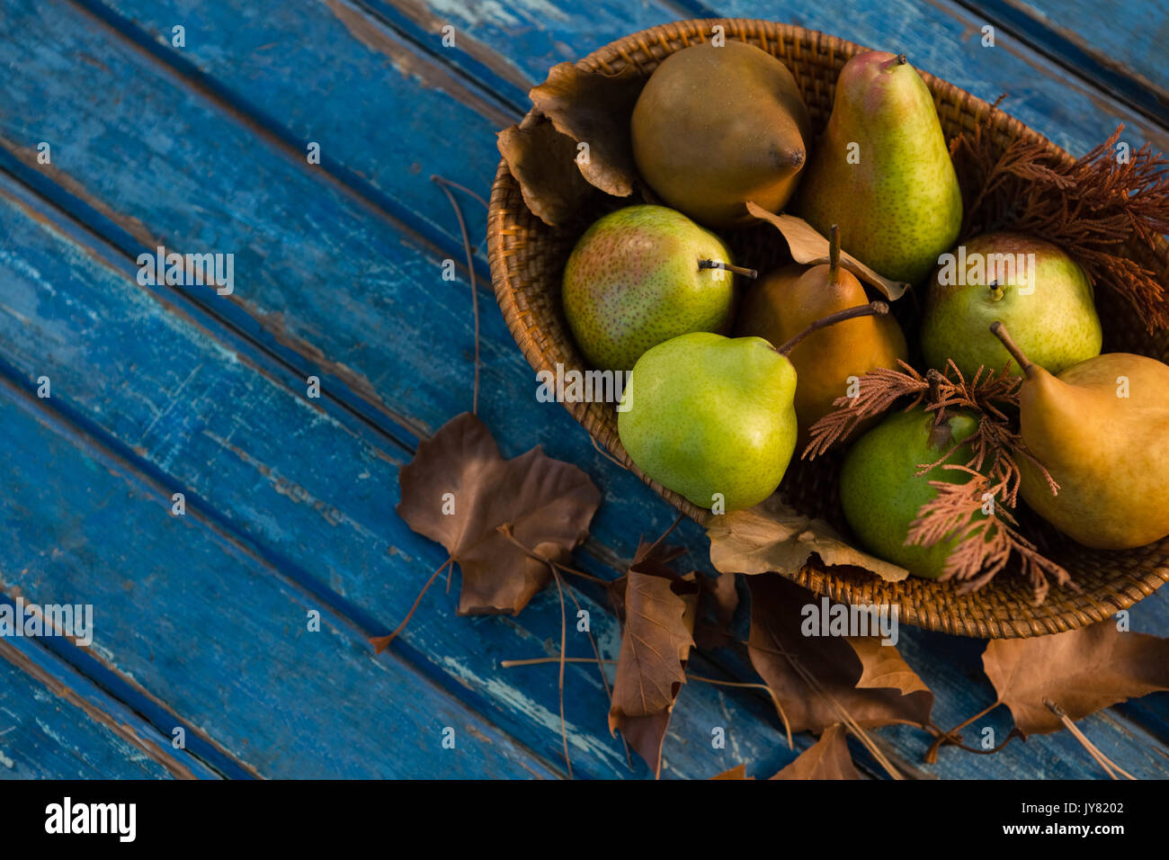 Portrait des poires au panier en osier sur la table en bois Banque D'Images