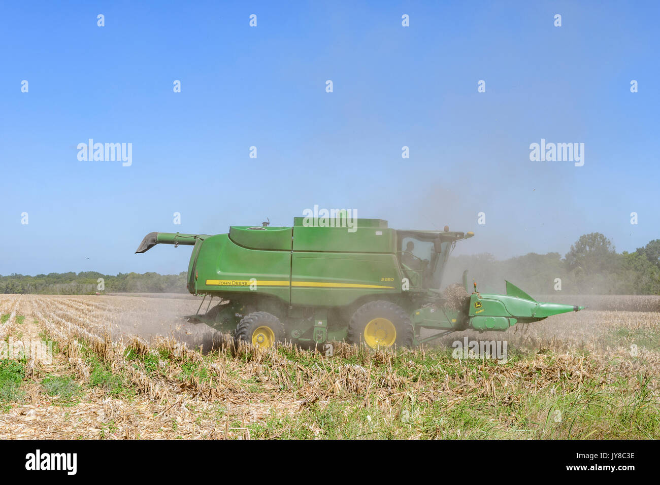 John Deere S550 combine harvester est vieille coupe les tiges de maïs récoltés pour préparer le terrain pour la récolte de l'année prochaine sur une ferme du centre de l'Alabama, USA. Banque D'Images