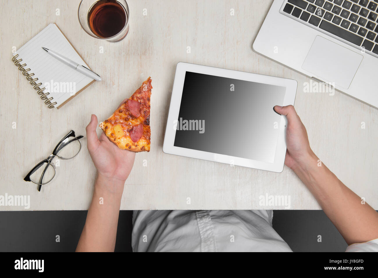 Homme tenant une tablette numérique et pizza savoureuse avec des ingrédients sur la table en bois. Banque D'Images Homme tenant une tablette numérique et pizza savoureuse avec des ingrédients sur la table en bois. Banque D'Images